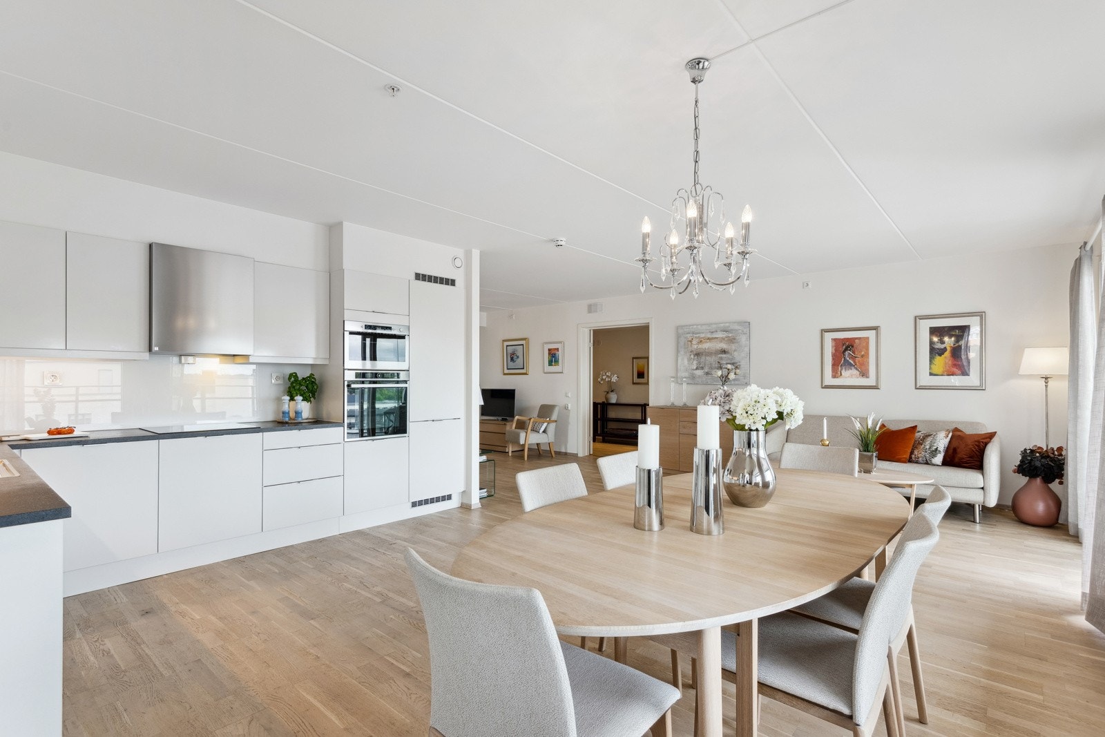 Den åpne løsningen skaper en sosial og god atmosfære i leiligheten, og gjør det til et perfekt sted å invitere venner og familie til hyggelige kvelder. Galleribilde