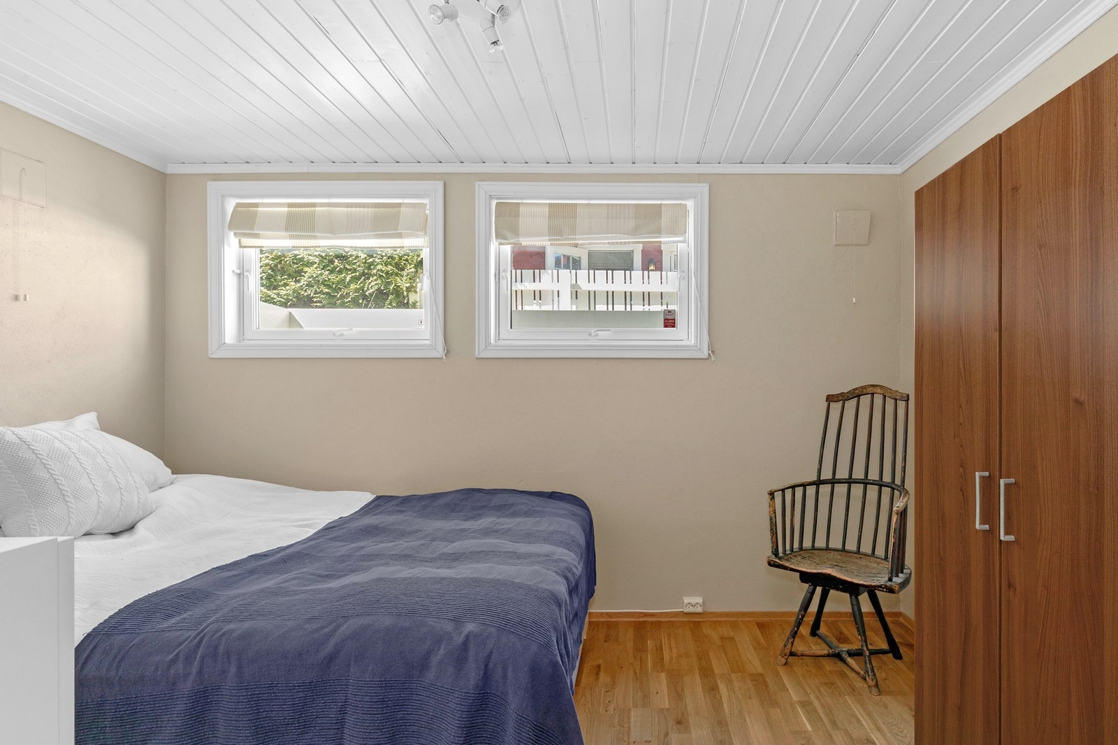 Dette soverommet har inngang fra kjellerstuen med rød sofa. Det har fin størrelse med god plass til dobbeltseng og garderobe. Sengen på bildet er 160 bred. Begge vinduene er godkjente som fluktåpninger og kan åpnes innover og vippes i luftestilling. Galleribilde