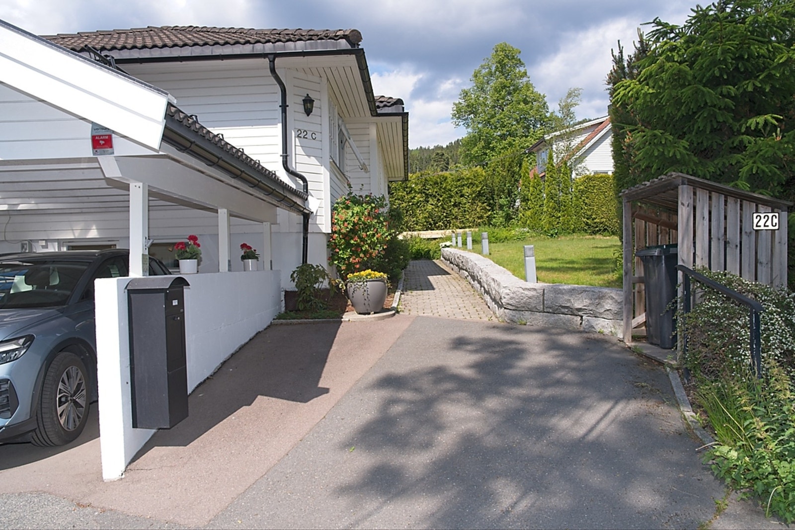 Stenlagt gangsti fra gårdplass og carport frem til inngangspartiet på nordsiden. Flott belysning langs stenmuren. Galleribilde