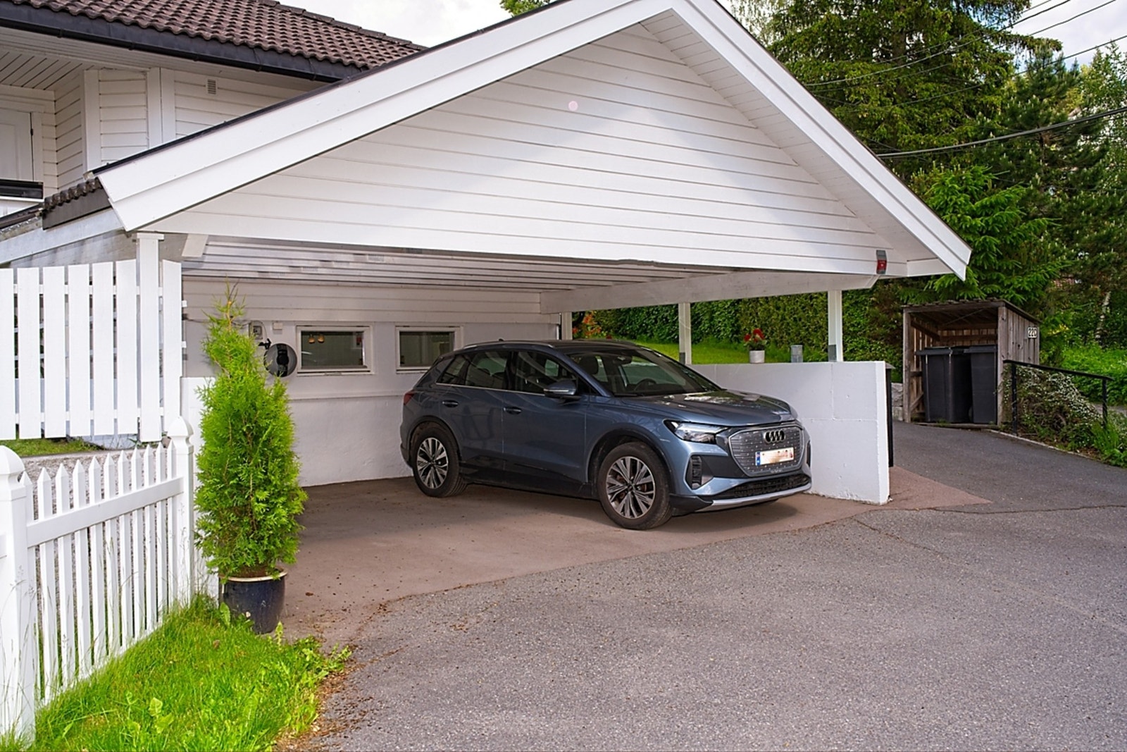Særdeles bred og høy carport med god plass til 2 biler og mer til. Til venstre i carporten er det inngang til sykkelbod. Elbil-lader på egen kurs. Galleribilde