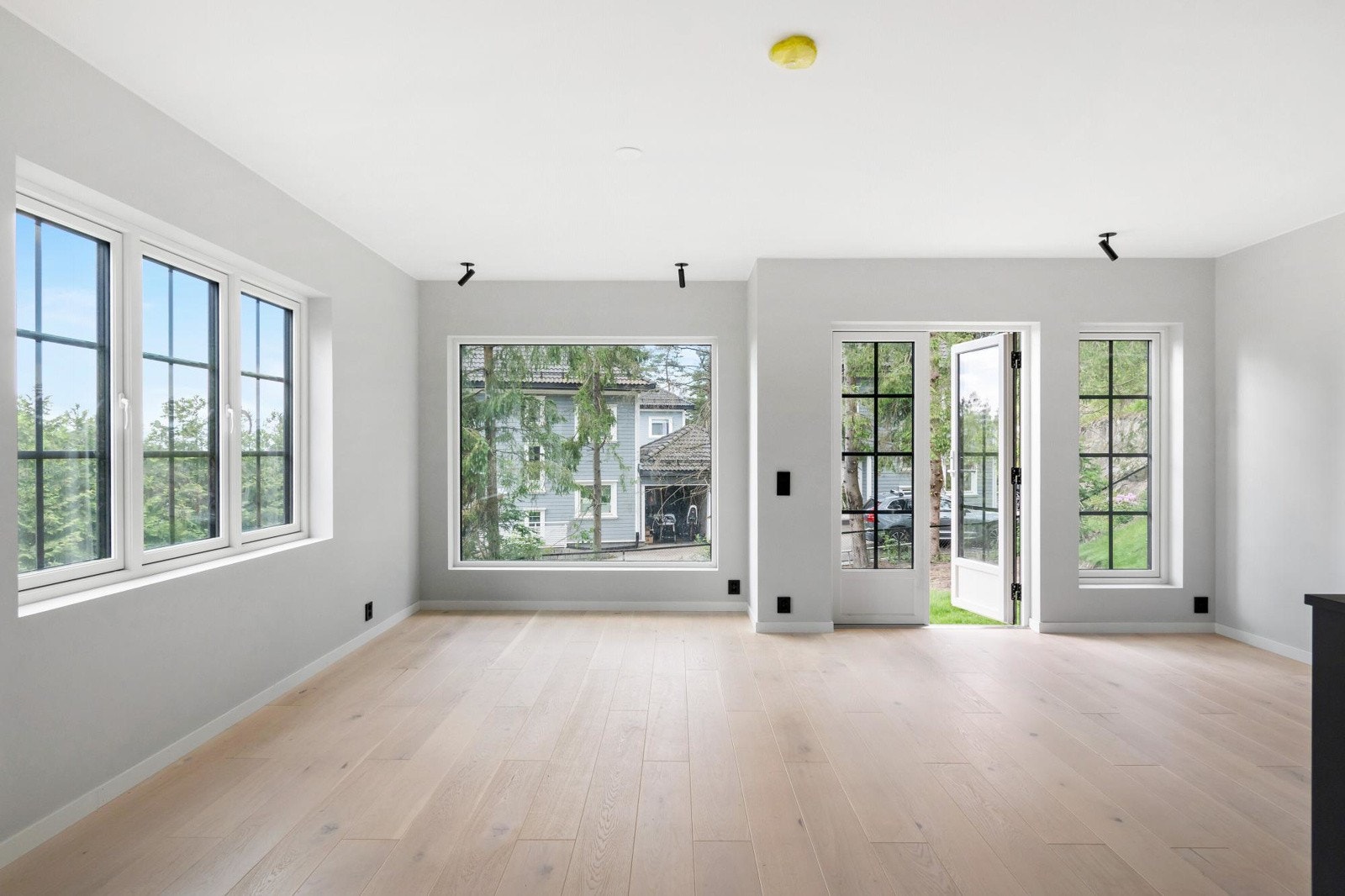 Stor og lys stue med åpen kjøkkenløsning og utgang til sydvendt terrasseplatting og hagedel med eksklusiv bruksrett. Galleribilde