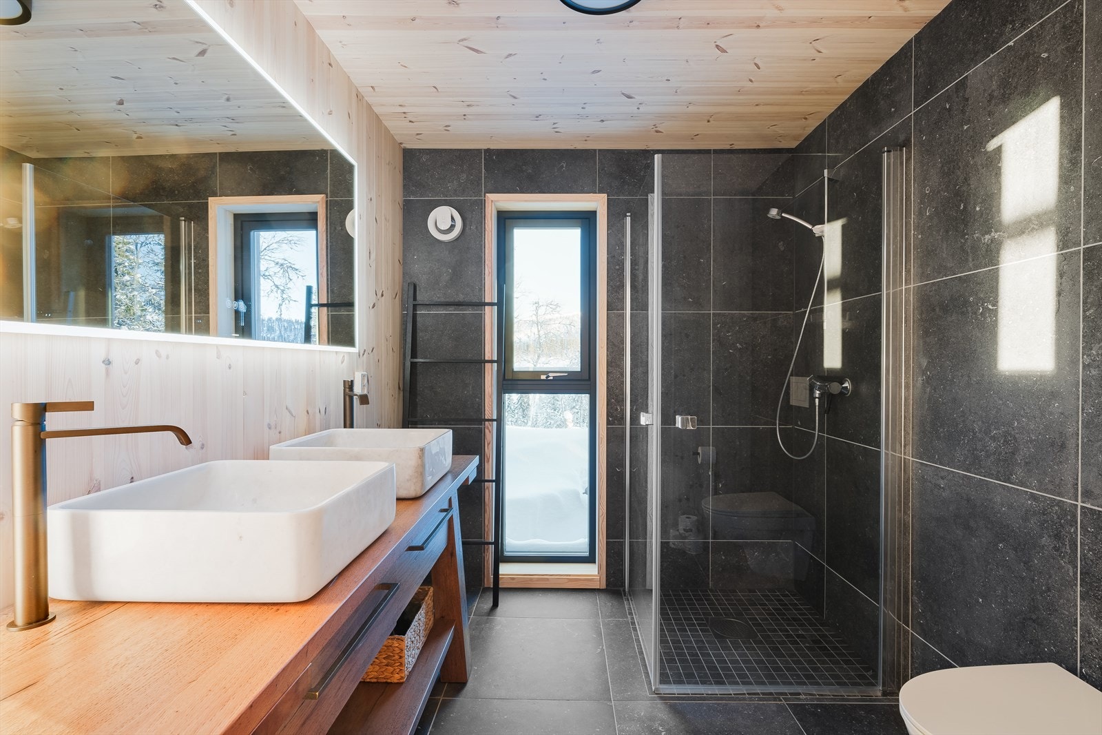 Moderne, flott bad med flislagte overflater. Innredning med to servanter, toalett og dusjdører i glass (selgers eget foto) Galleribilde