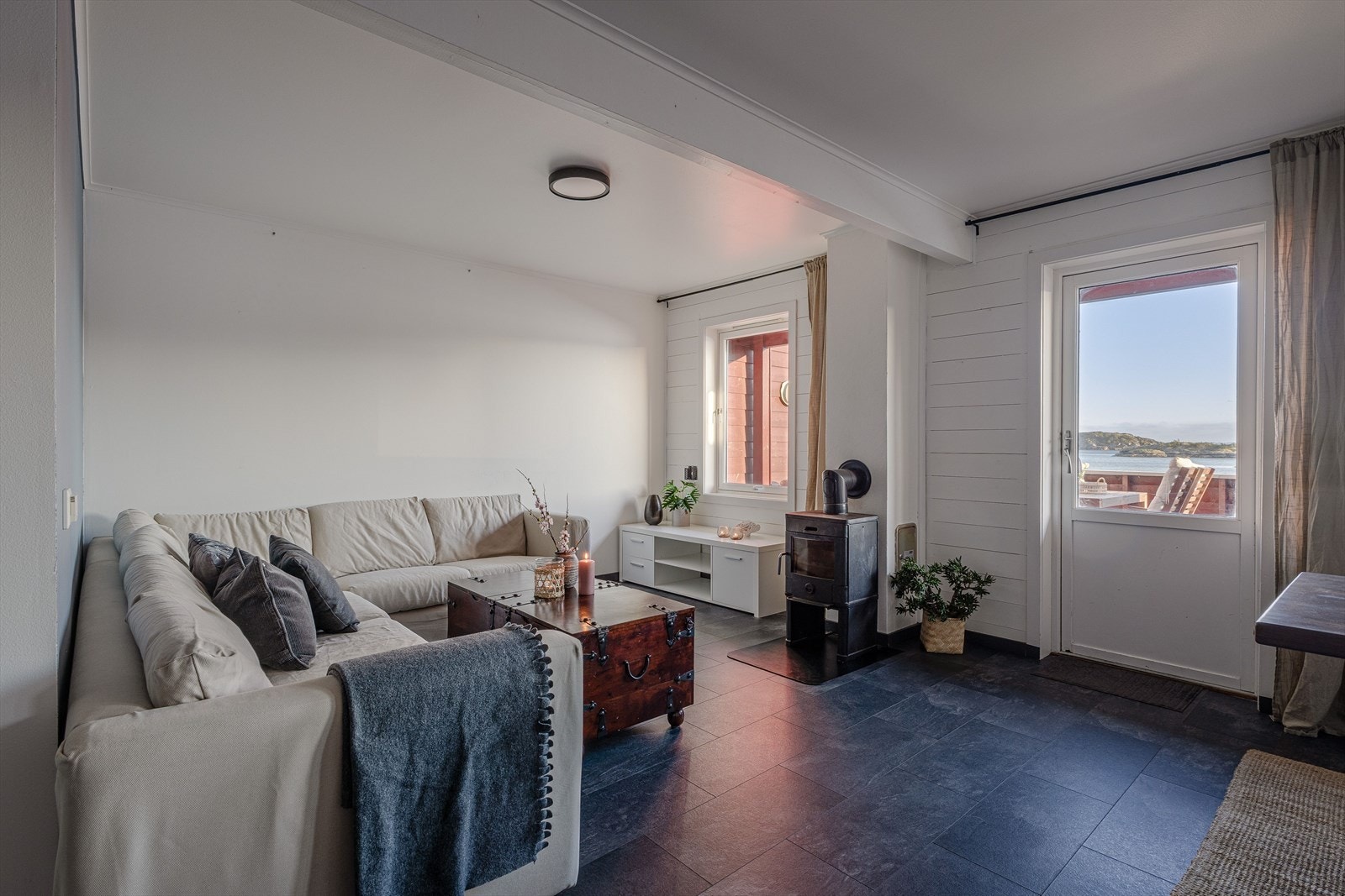 Stuen er lun og koselig og varmes opp av peisovnen Galleribilde