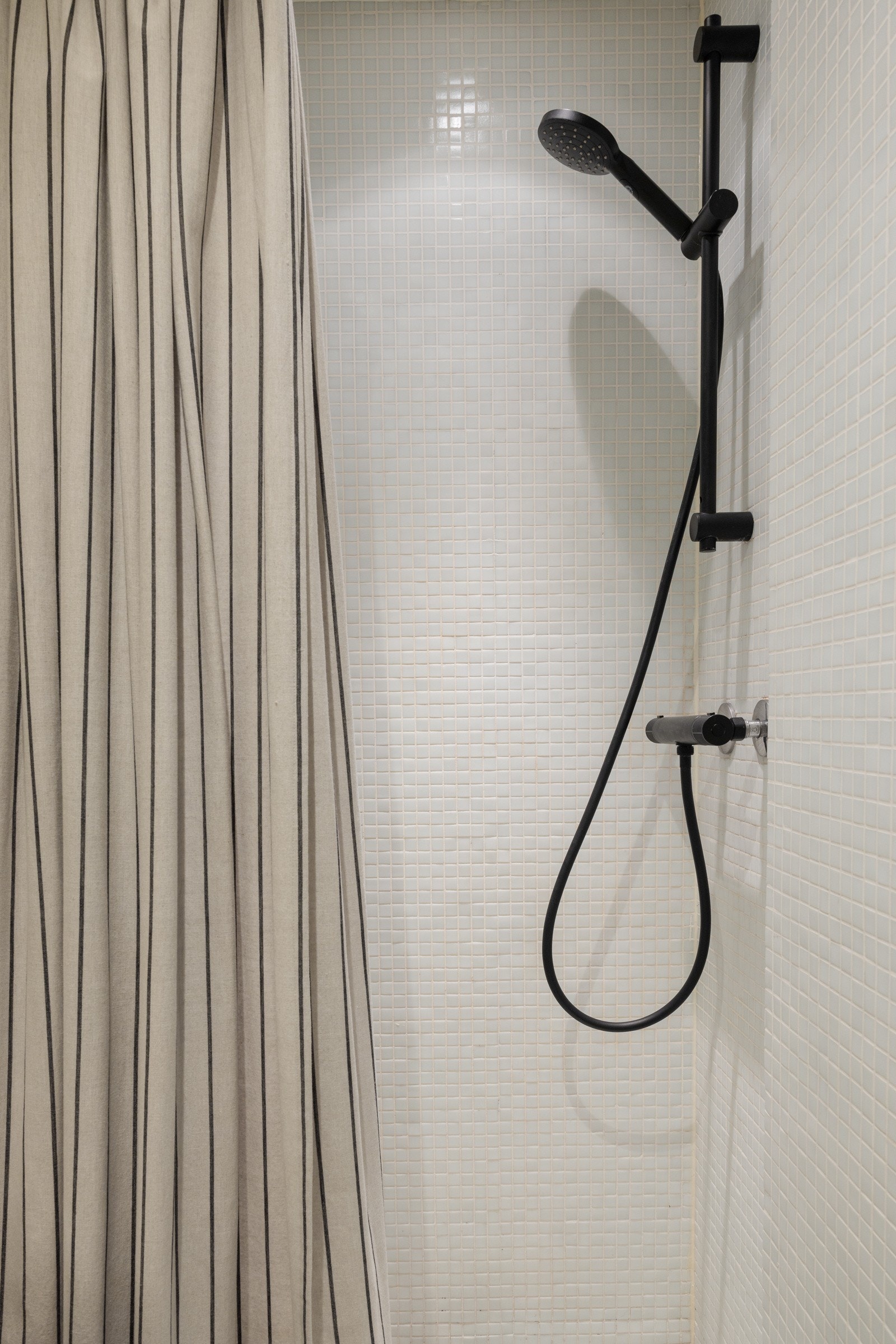 Innbydende dusjsone med delikat dusj som står i stil med baderommet, og lyse, innbydende fliser som gir et rent og moderne uttrykk. Galleribilde