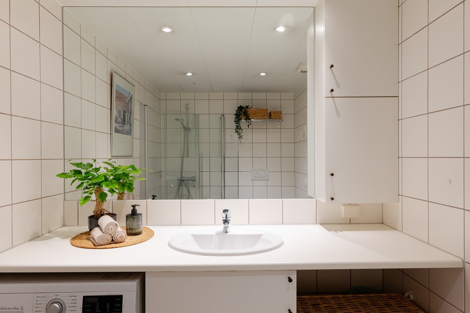 Det er vegghengt toalett og opplegg for vaskemaskin og tørketrommel i praktisk og plassbesparende nisje. Galleribilde