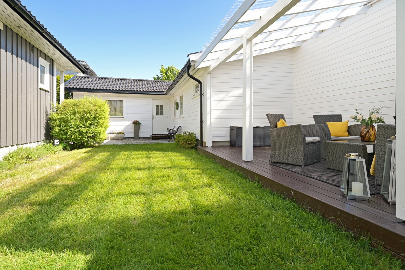 På baksiden av huset finner du i tillegg en overbygget terrasse på 16 m². Denne innbydende uteplassen er ideell for lange sommerkvelder med familie og venner, med god plass til både grill og sittemøbler. Galleribilde