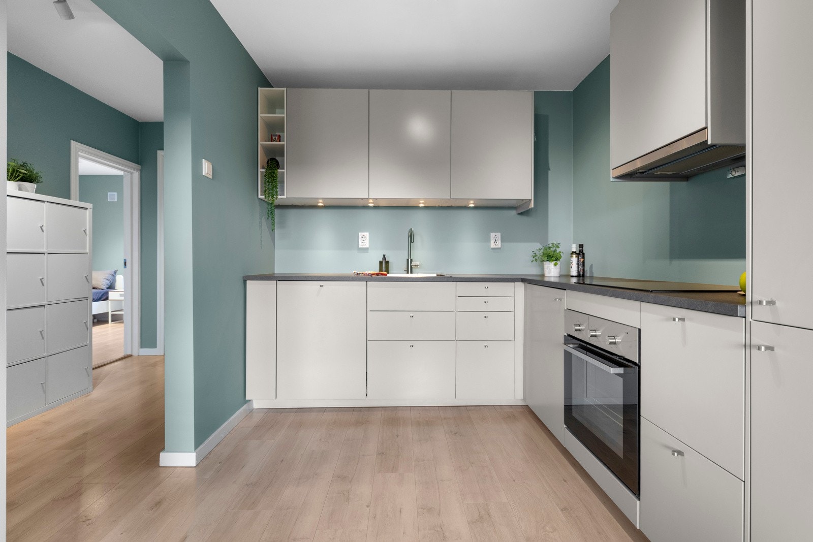 Kjøkkenet har integrerte hvitevarer som inkluderer platetopp, komfyr, kjøl/frys og oppvaskmaskin Galleribilde