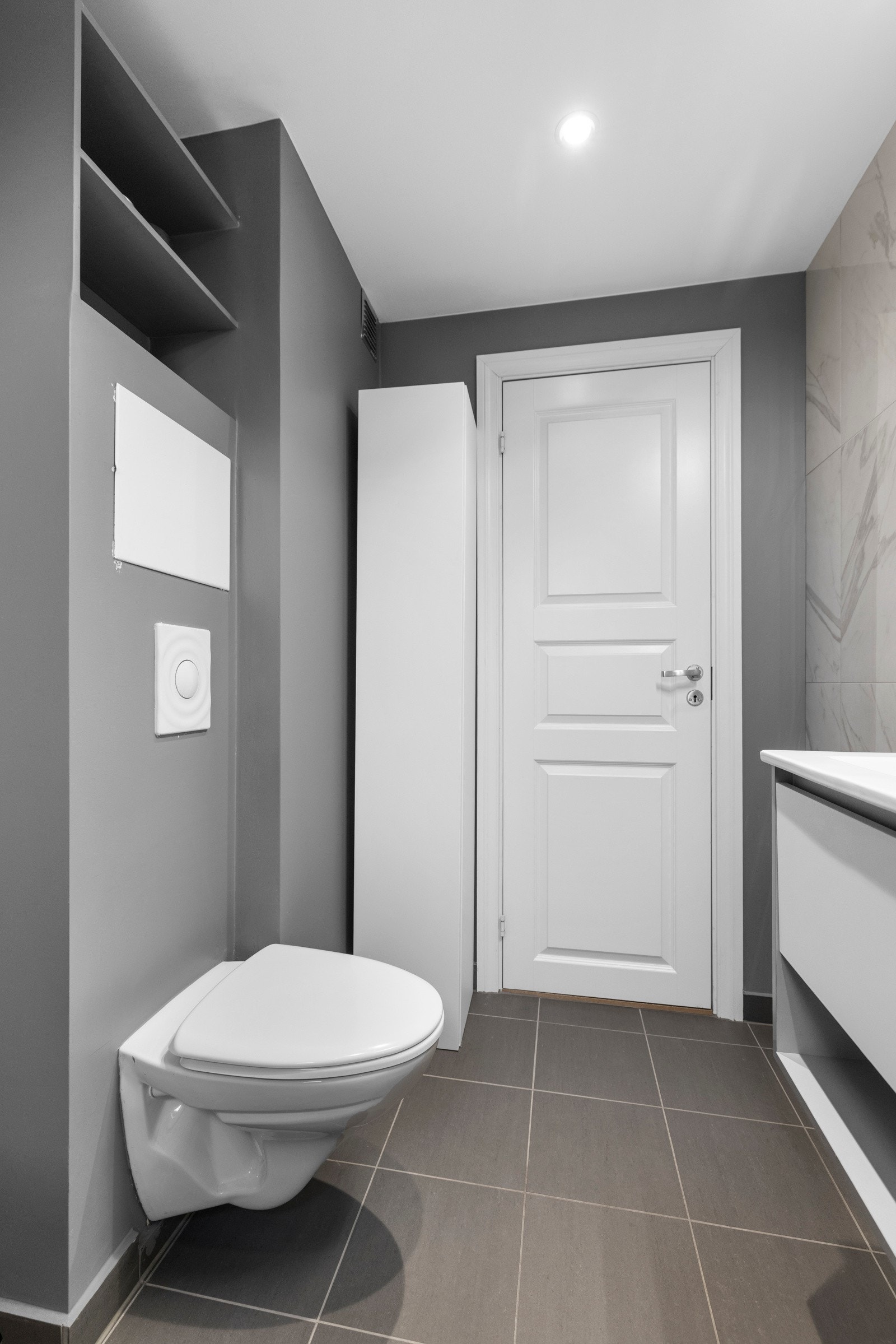 Innredningen inkluderer en heldekkende servant, med en underhengene oppbevaringsløsning med slette fronter, og opplegg for vaskemaskin Galleribilde