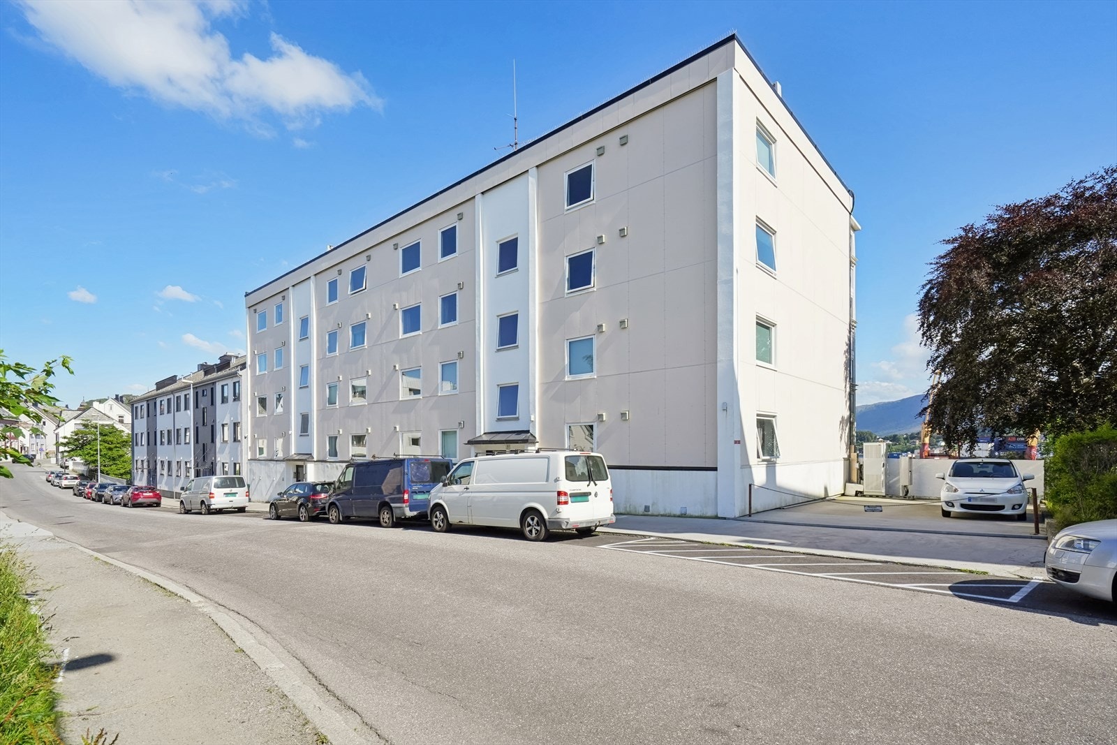 Borettslaget har etablert el-billader på ene parkeringsplassen til høyre. Ellers er det først til mølla-prinsippet på plassene foran blokka. Velkommen til visning! Galleribilde