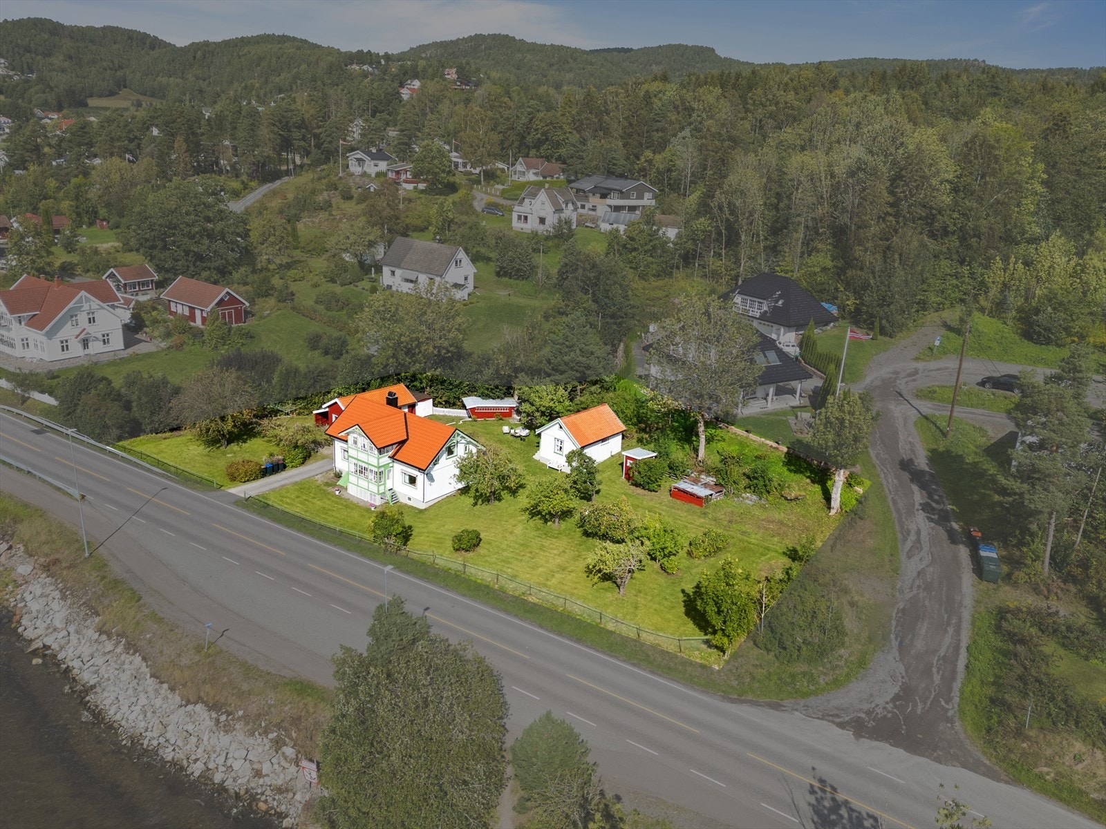 Stor og meget pent opparbeidet selveiertomt med innkjøring, gårdsplass, fine plenarealer med beplantninger, frukttrær etc. Egen strandparsell på nedsiden av eiendommen som man deler bruk sammen med nabo på baksiden. Galleribilde