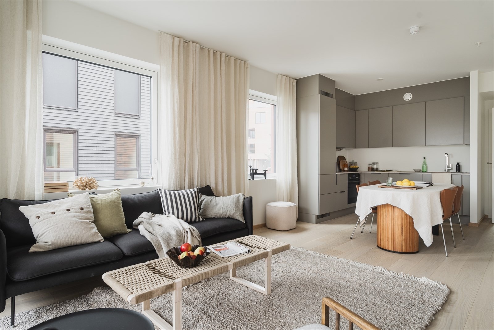 Lyst og luftig oppholdsrom med stue og kjøkken i åpen løsning Galleribilde