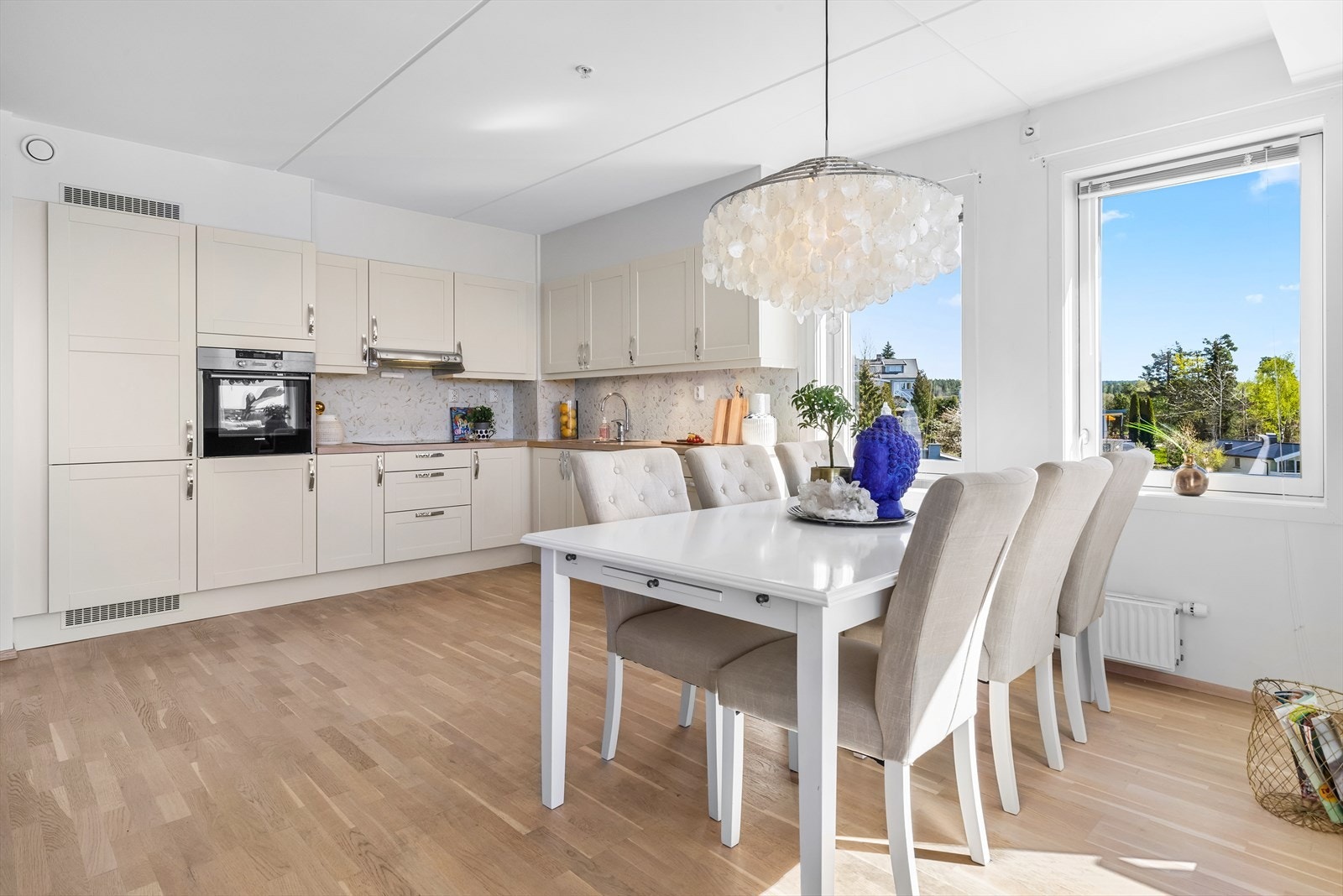 Kjøkkeninnredningen er levert av HTH og har profilerte fronter, belysning under overskapene og vegger med stilfulle mosaikkfliser over benkene. Benkeplaten er i eik med nedfelt kum i rustfritt stål. Galleribilde