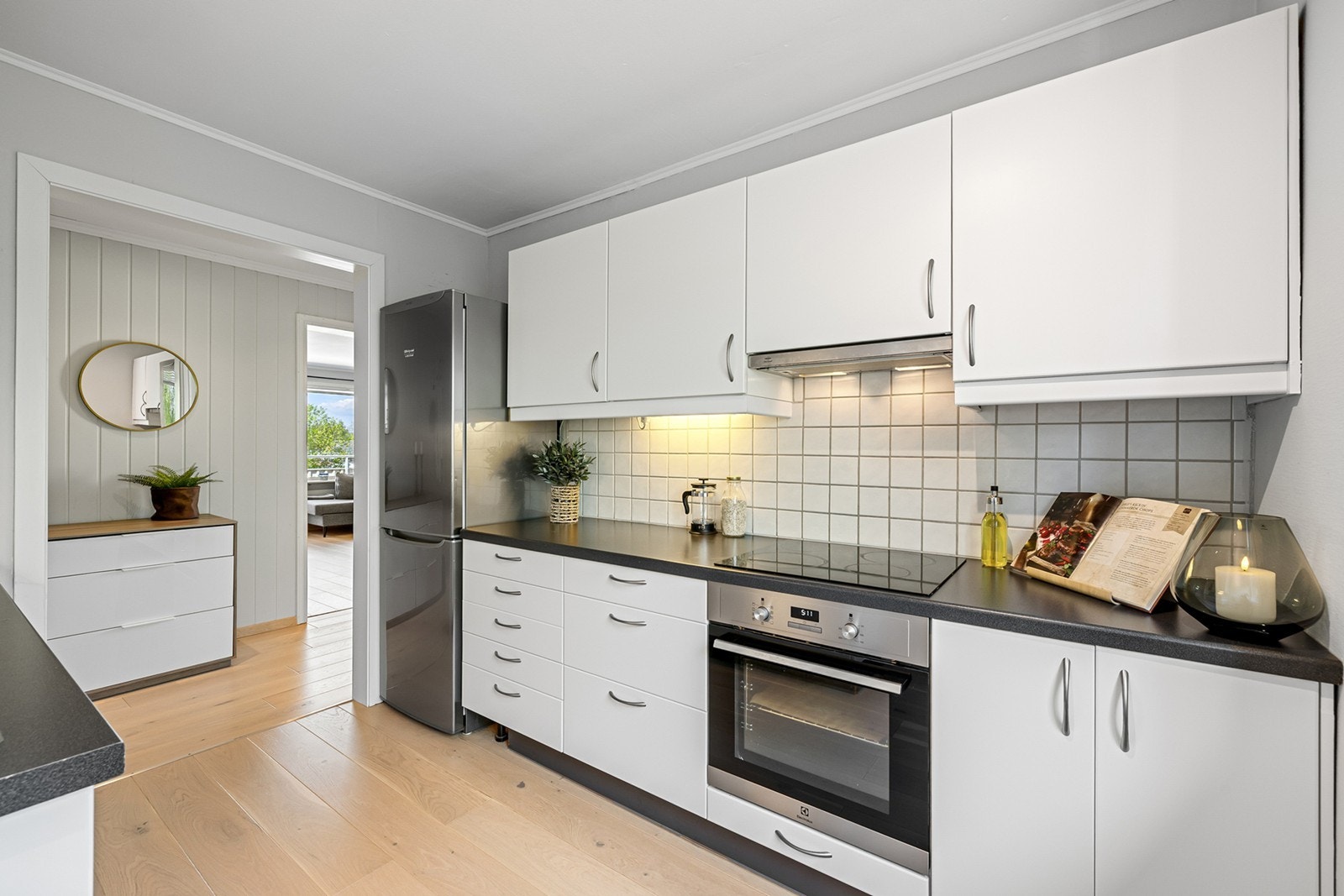 Moderne kjøkkeninnredning med hvite glatte fronter og laminert benkeplate med nedfelt oppvaskkum. Galleribilde