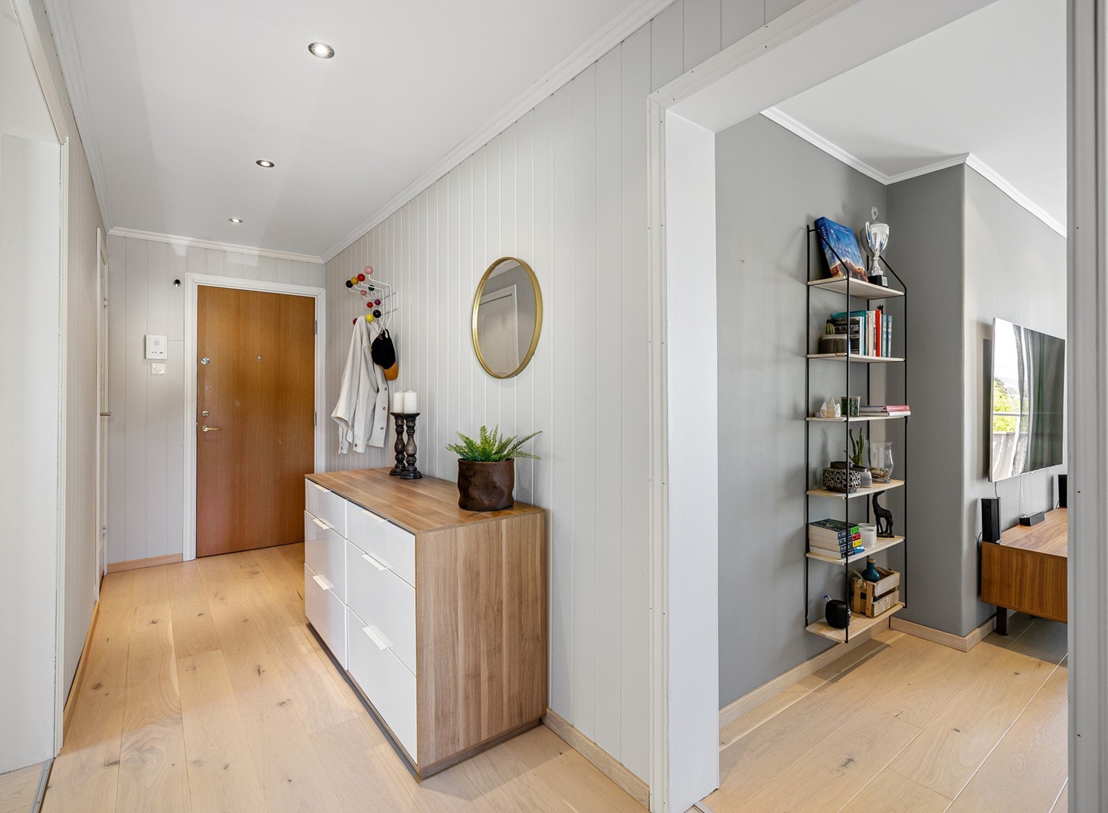 Innenfor døren kommer du til en romslig og hyggelig entré med parkettgulv og lyse panelplater på veggene, og i taket er det godt lys fra downlights. Galleribilde