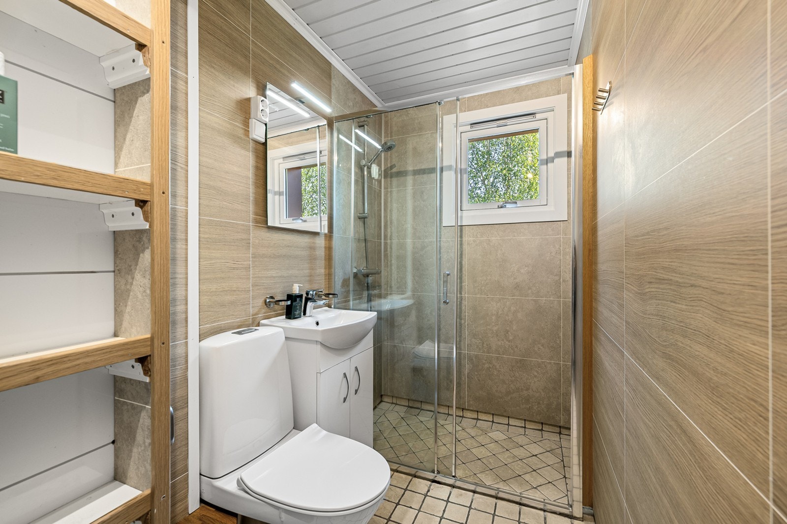 Badet har opplegg for vaskemaskin og rommet har et lite vindu. Galleribilde