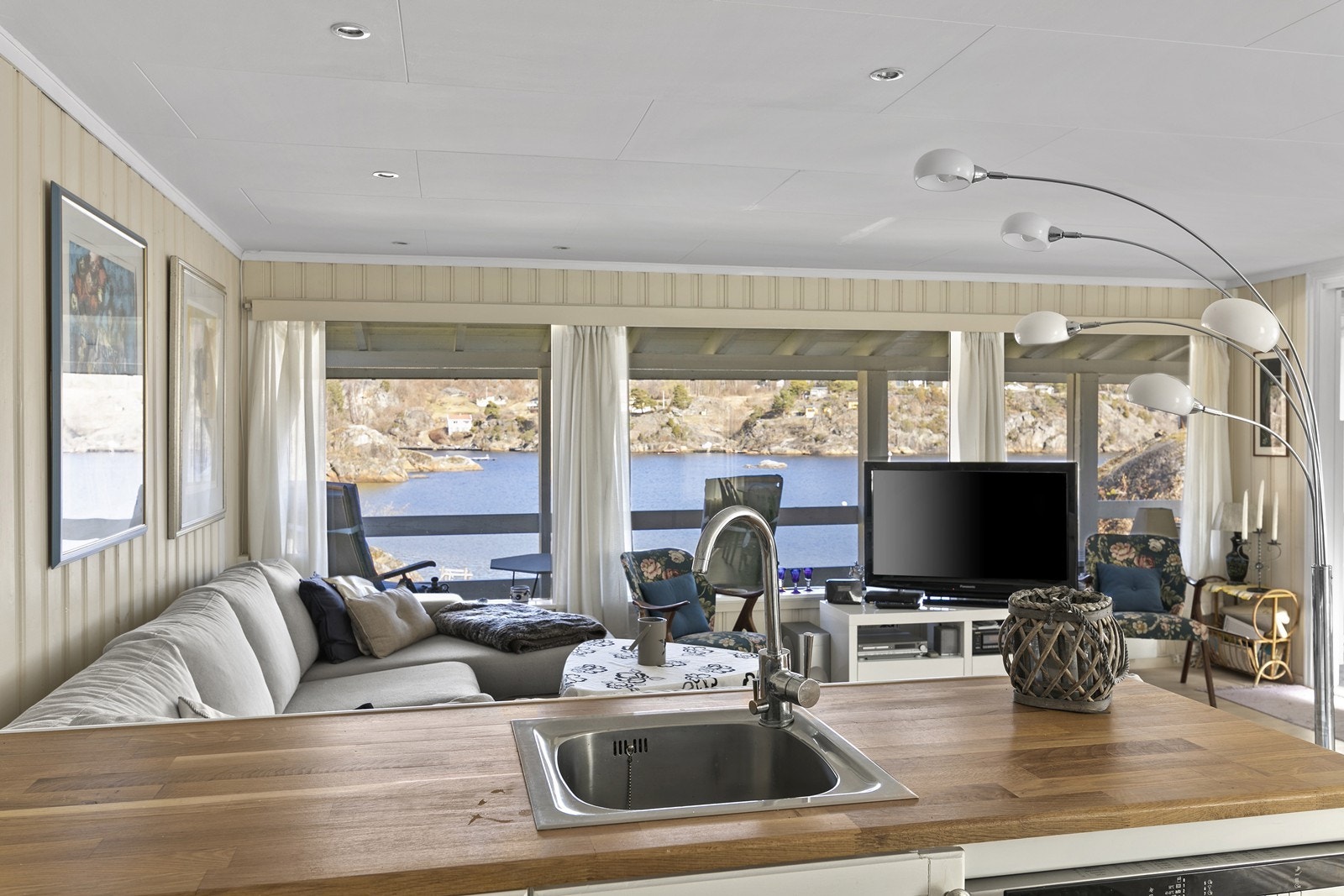 Lys stue med store vindusflater som gir fantastisk utsikt utover sjøen. Galleribilde