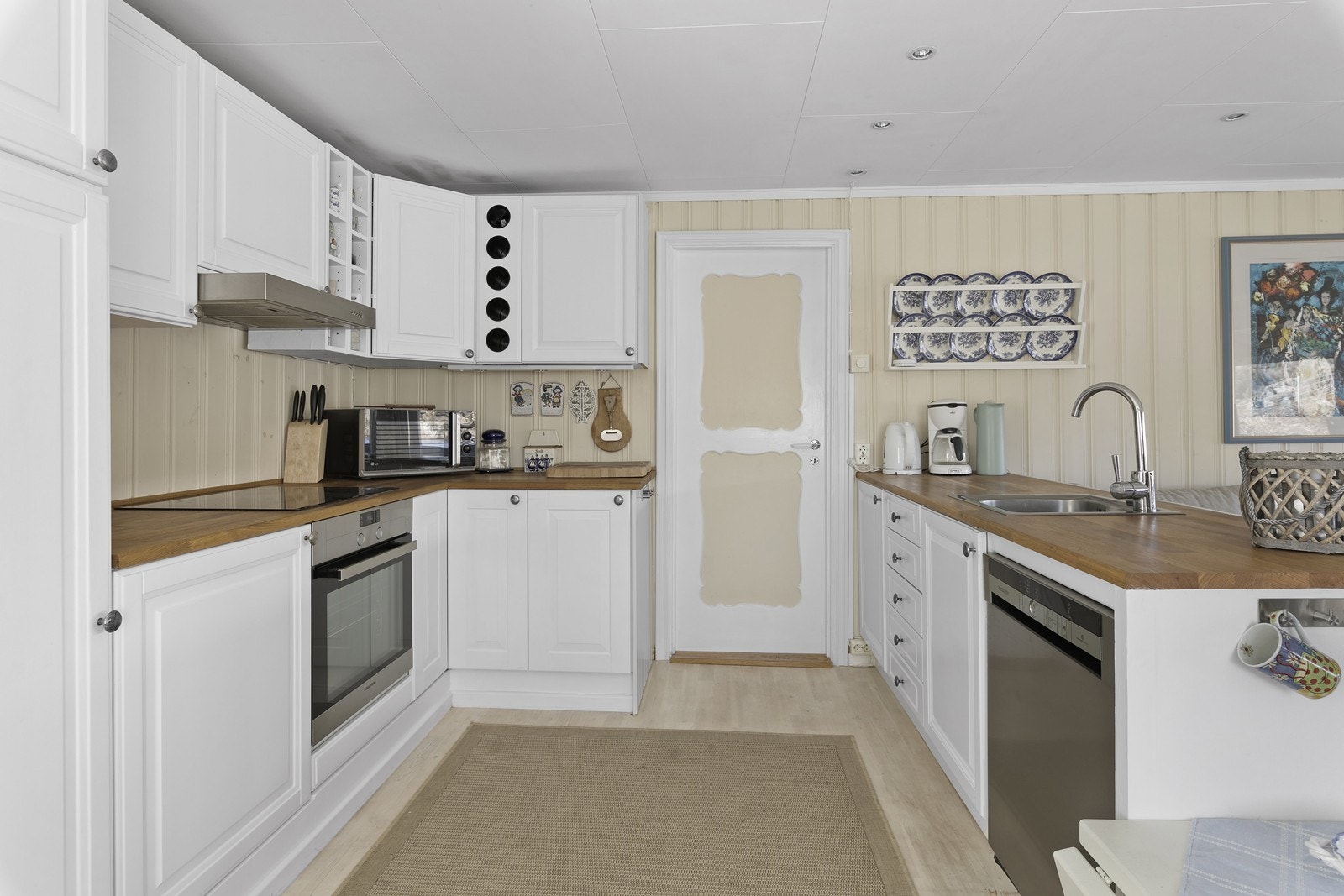 Kjøkkenet har hvitmalt innredning med profilerte fronter. Galleribilde