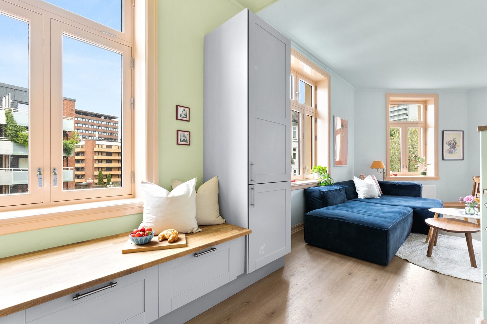 Veggen mellom kjøkken og stue er revet. Dette gir en åpen og sosial løsning som innbyr til høy trivselfaktor. Galleribilde