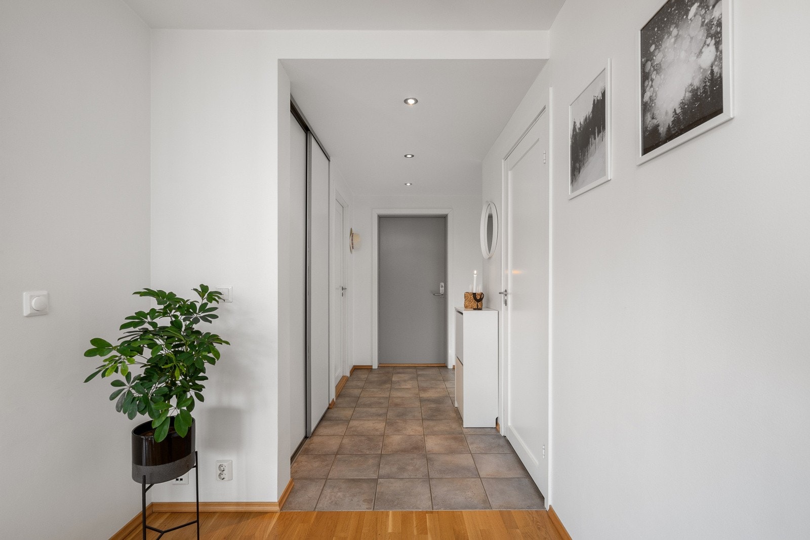 Entréen er lys og innbydende med lysmalte overflater og downlights i himlingen. Galleribilde