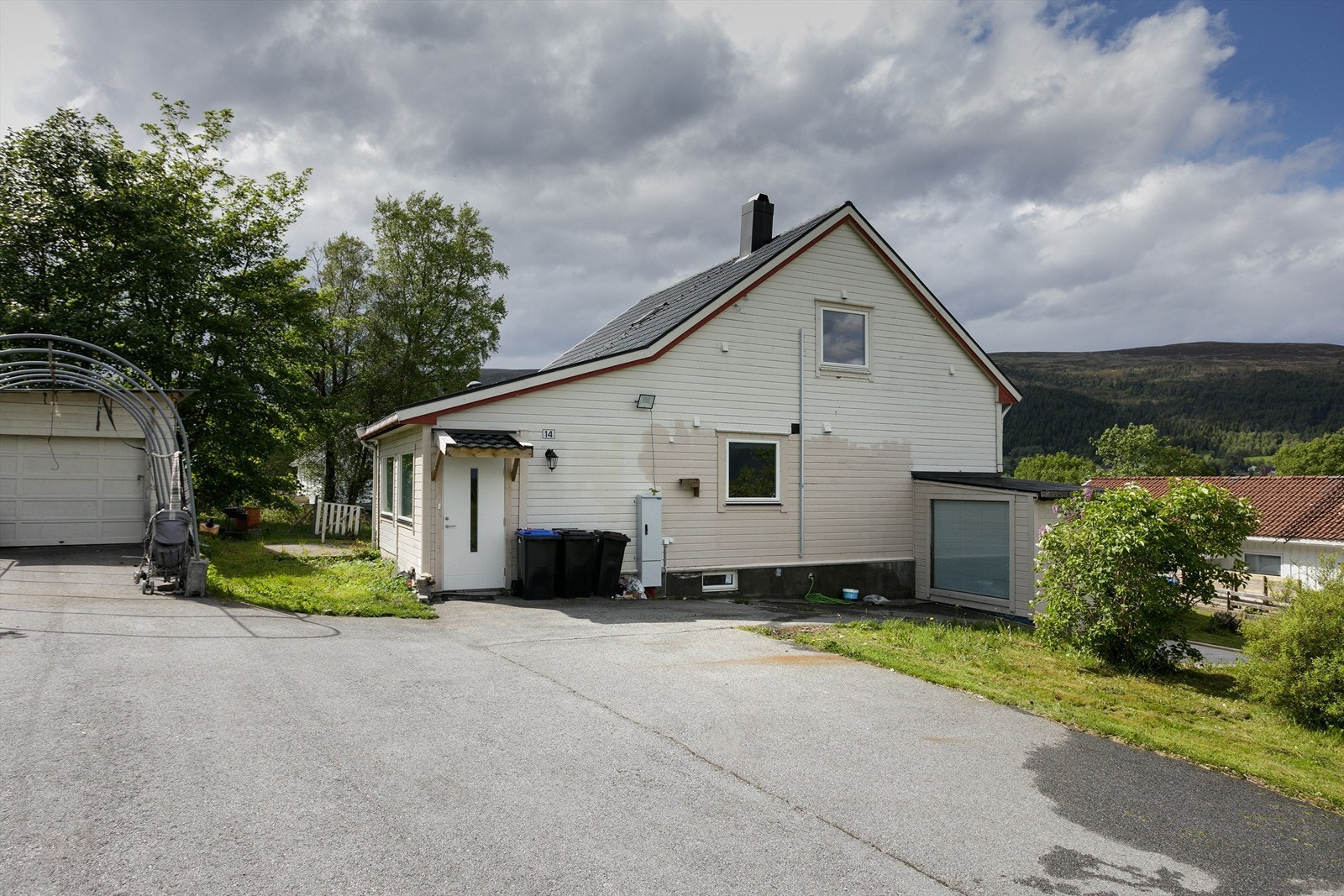 Fasade og adkomstveg med asfaltert parkeringsareal på egen tomt Galleribilde