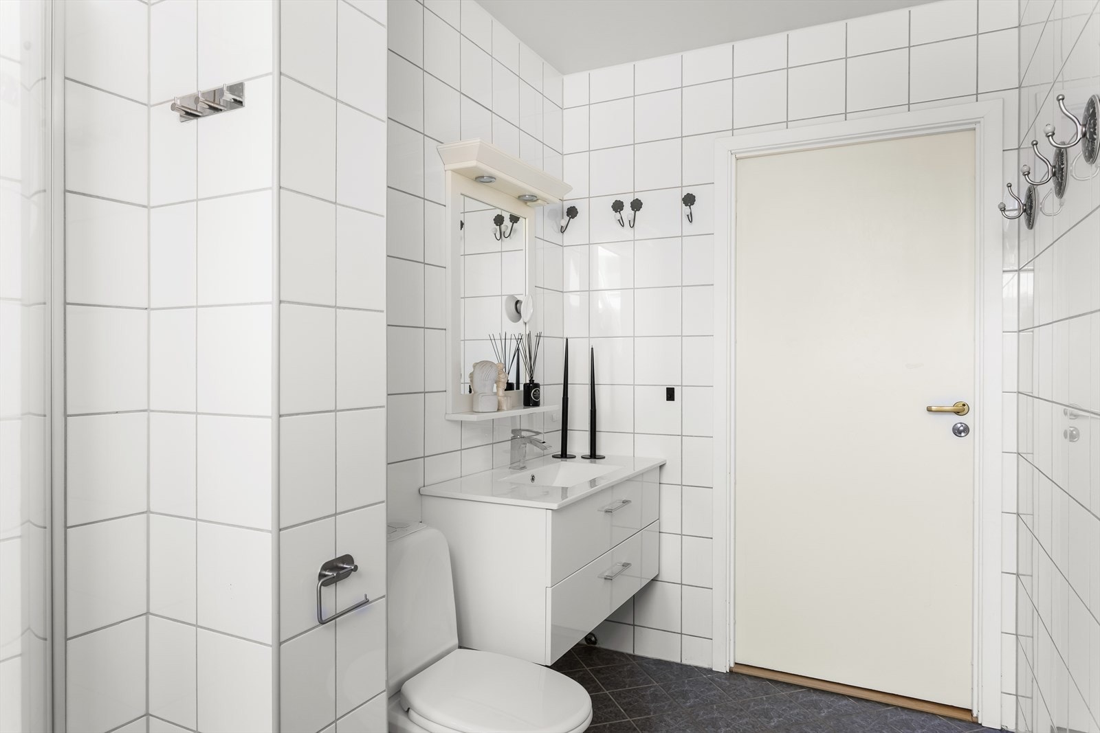 Badet har moderne servant med underskap, speil med belysning og dusj. Galleribilde