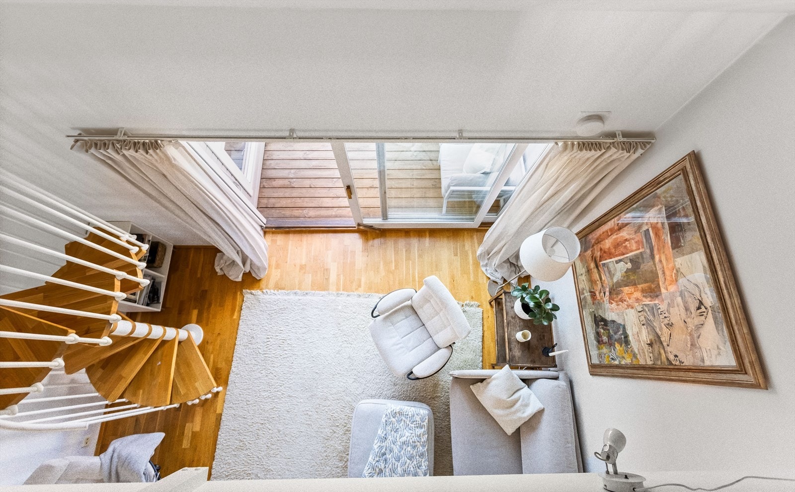 Stue med åpen løsning og spiraltrapp gir boligen et luftig og moderne preg. Galleribilde