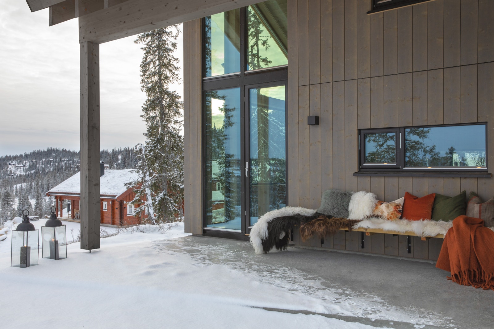 Hyttemodellen har en stor terrasse under tak – med fastmontert benk. På terrassen er det også inngang til en utebod. Galleribilde