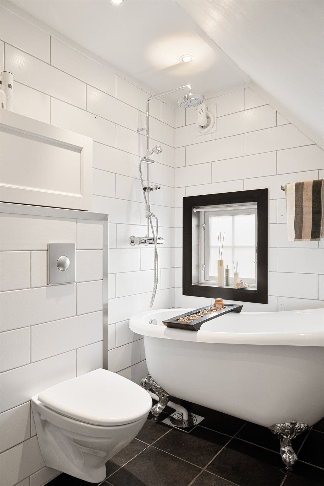 Badet er innredet med vegghengt toalett, servant i baderomsmøbel og herlig badekar med dusj. Galleribilde