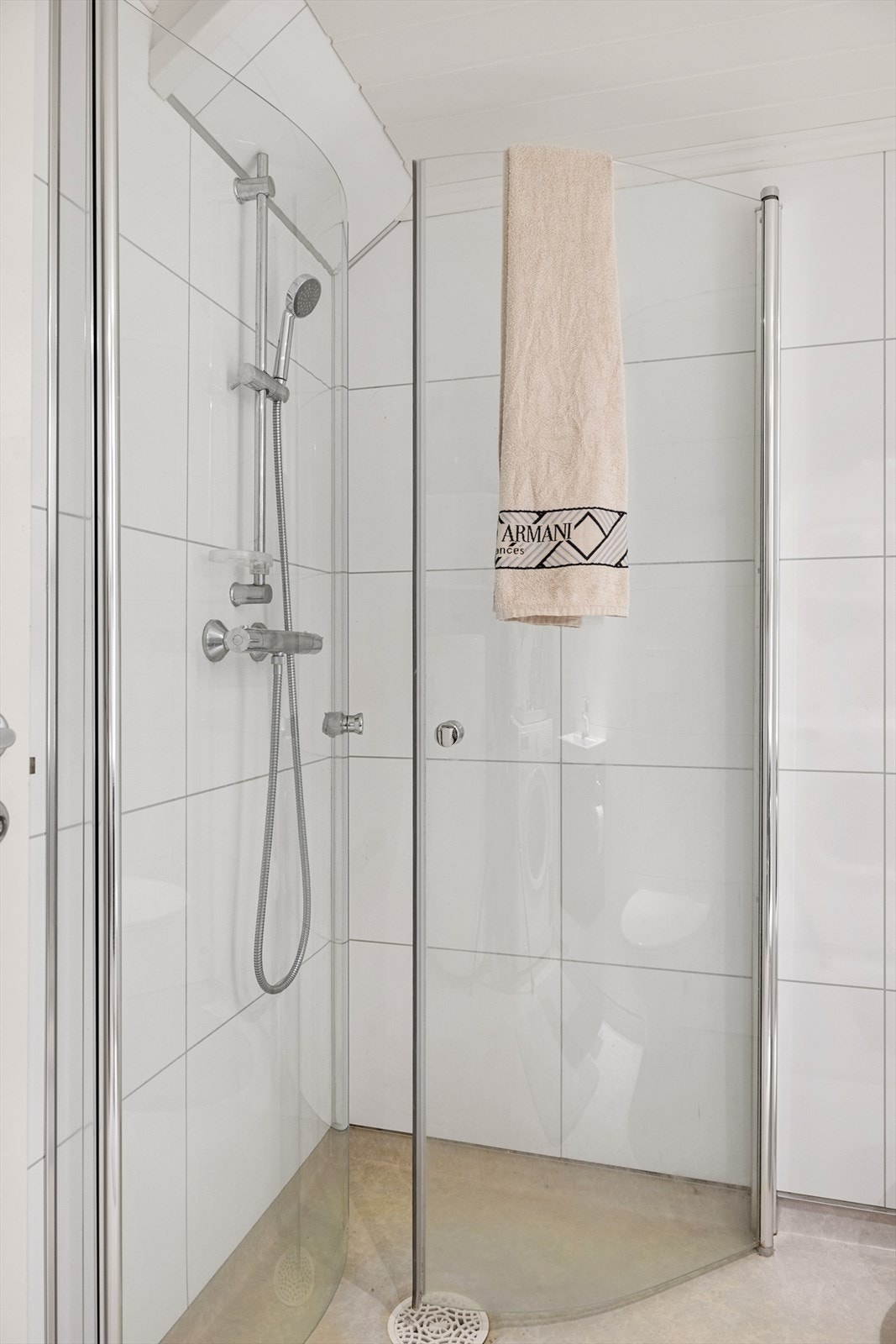 Badet er innredet med vegghengt toalett, servant i baderomsmøbel og dusjhjørne. Galleribilde