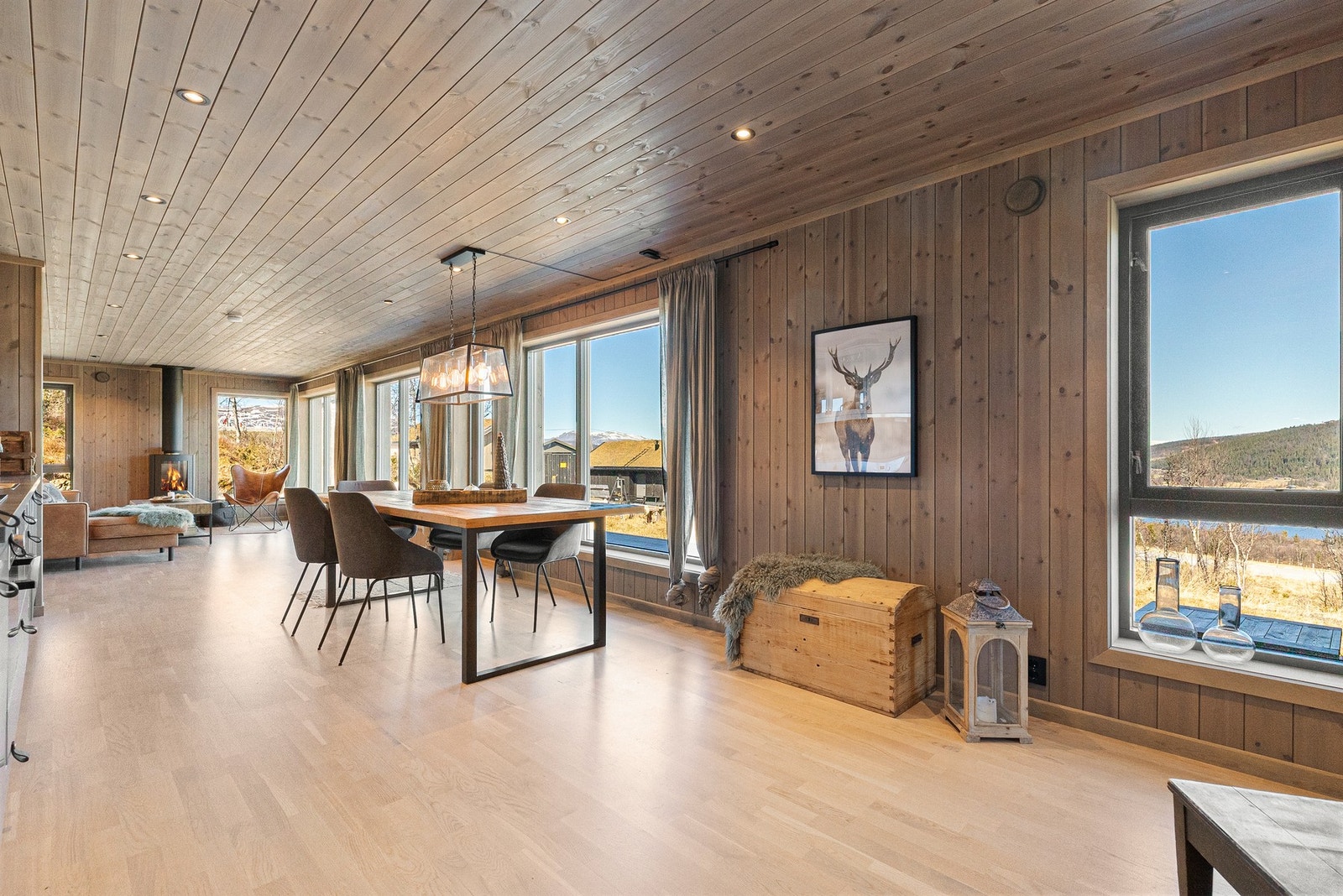 Romslig og åpen løsning med stue og kjøkken med store vindusflater Galleribilde