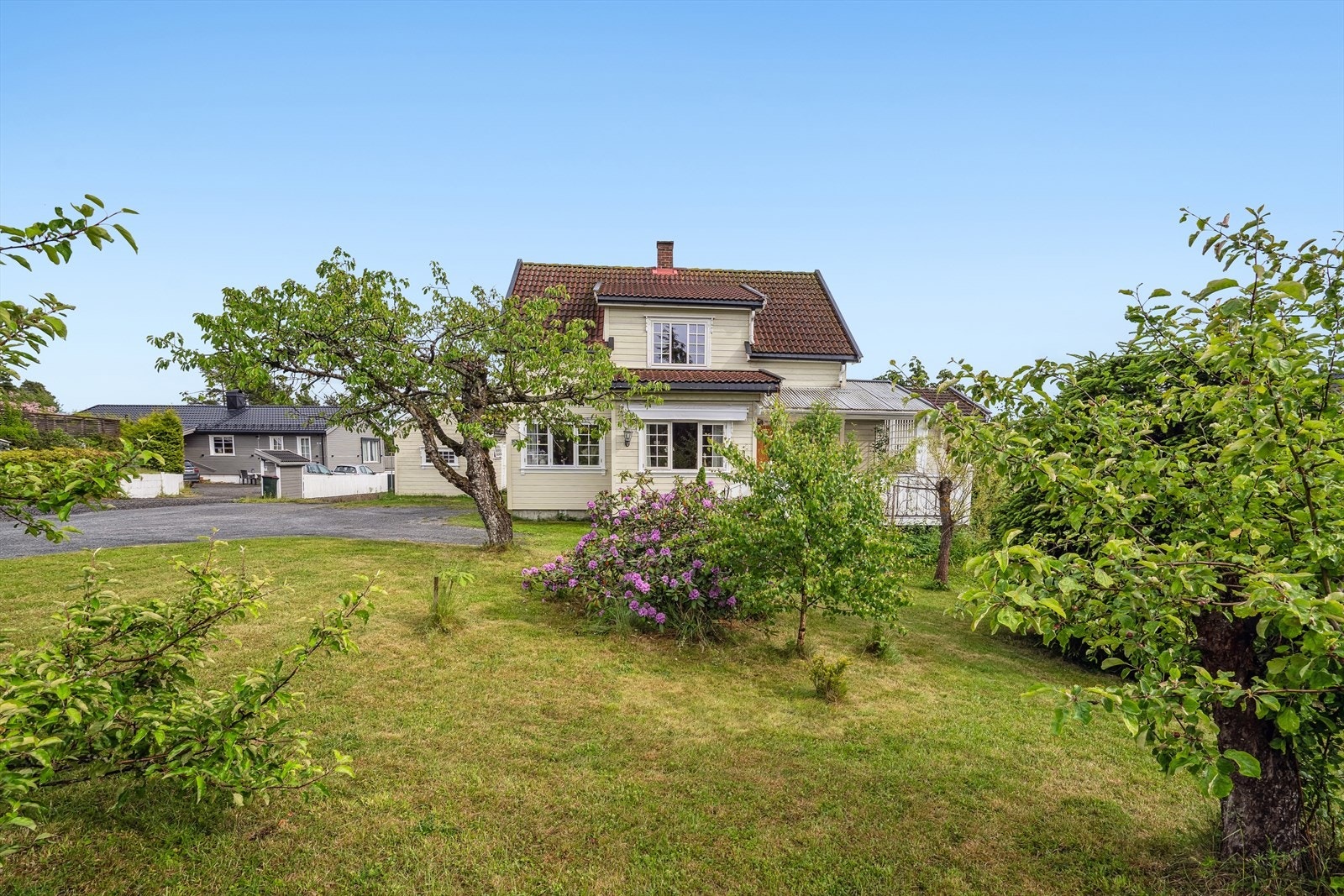 Tomten er pent opparbeidet med gressplen, beplantninger samt noen prydbusker. Galleribilde