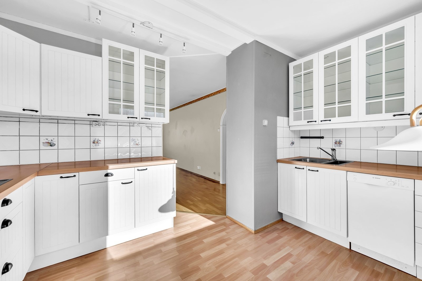 Det er videre satt inn benkeplate i laminat med nedfelt kum i rustfritt stål, samt fliser over benkeplaten og belysning under overskap. Galleribilde