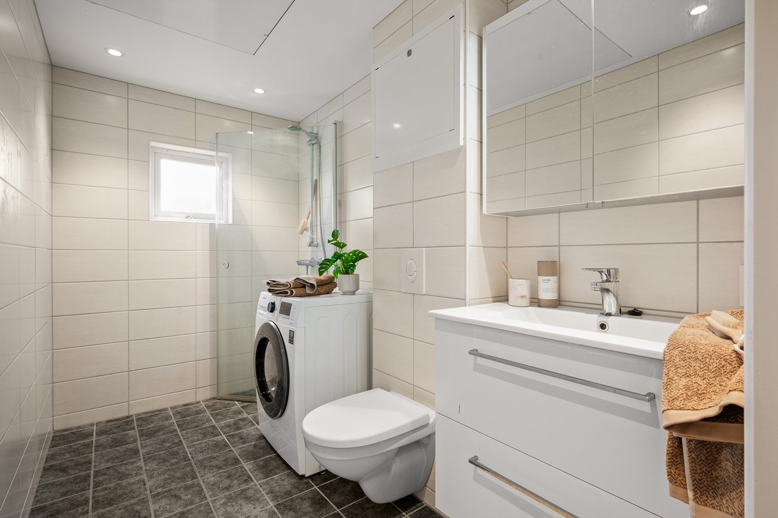 Badet ble oppgradert i 2019 i regi av borettslaget. Badet er innredet med vegghengt toalett, helstøpt servant med skuffer i slette fronter under, samt dusjdører i klart glass. Det er også opplegg for vaskemaskin. Galleribilde