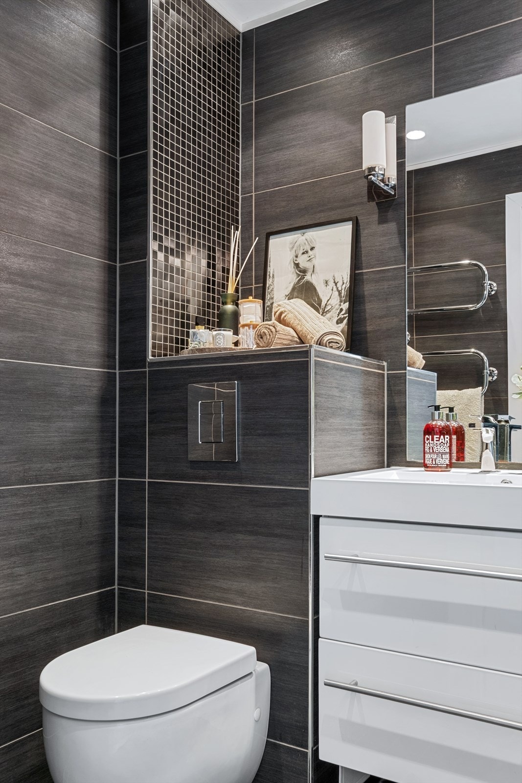 Badet har vegghengt toalett med innebygget sisterne. Galleribilde