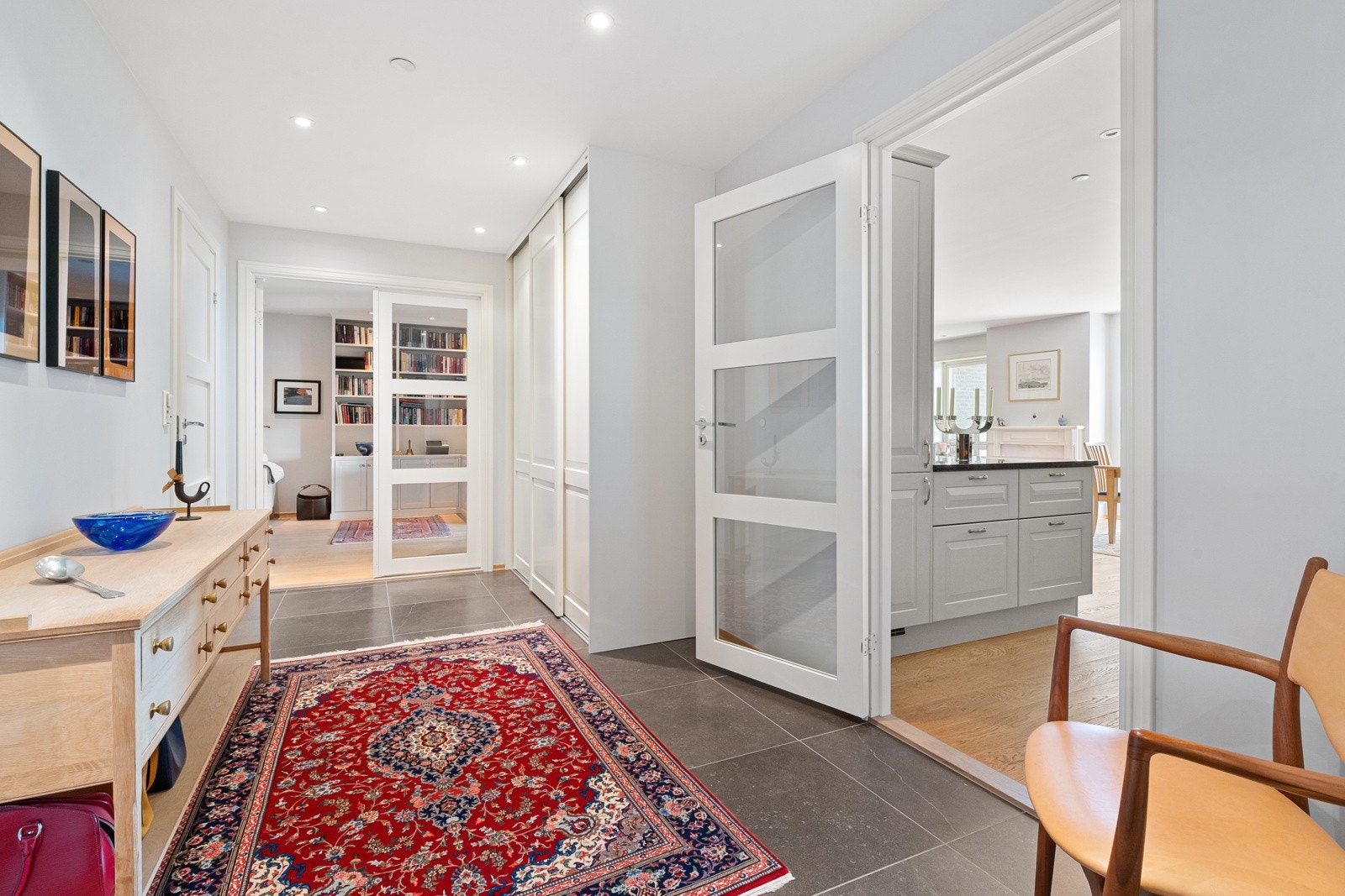 En takhøy, innebygd skyvedørsgarderobe med hvite, profilerte fronter gjør det enkelt å holde orden. Galleribilde