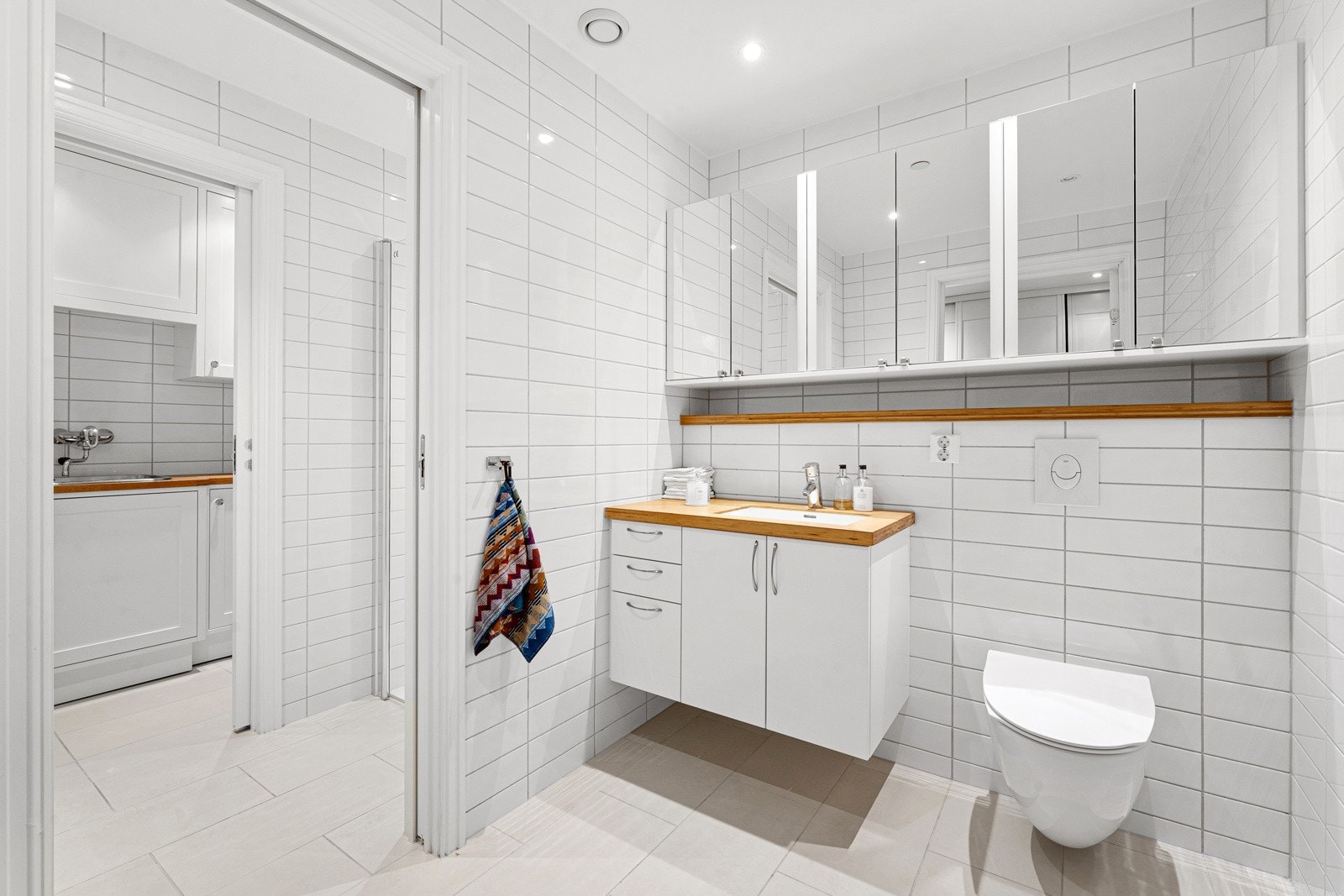 Badet med adkomst fra hallen er tredelt med en vaskeromssone i indre del, dusjsone i midten og toalettrom i ytterste del ved inngangen. Galleribilde