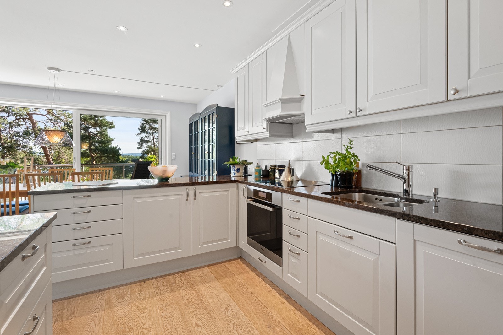 Induksjonstopp og stekeovn med dampfunksjon fra Miele, oppvaskmaskin og kjøl/frys er integrert, og ventilatoren er bygd inn i en kledelig hette. Galleribilde