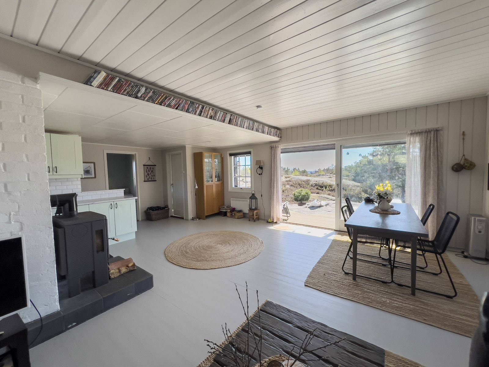 Skyvedør i glass mot syd, som fører ut til fine uteplasser opparbeidet med både heller og treplatting. Uteplassene har utsikt til havet og rikelig med sol. Galleribilde