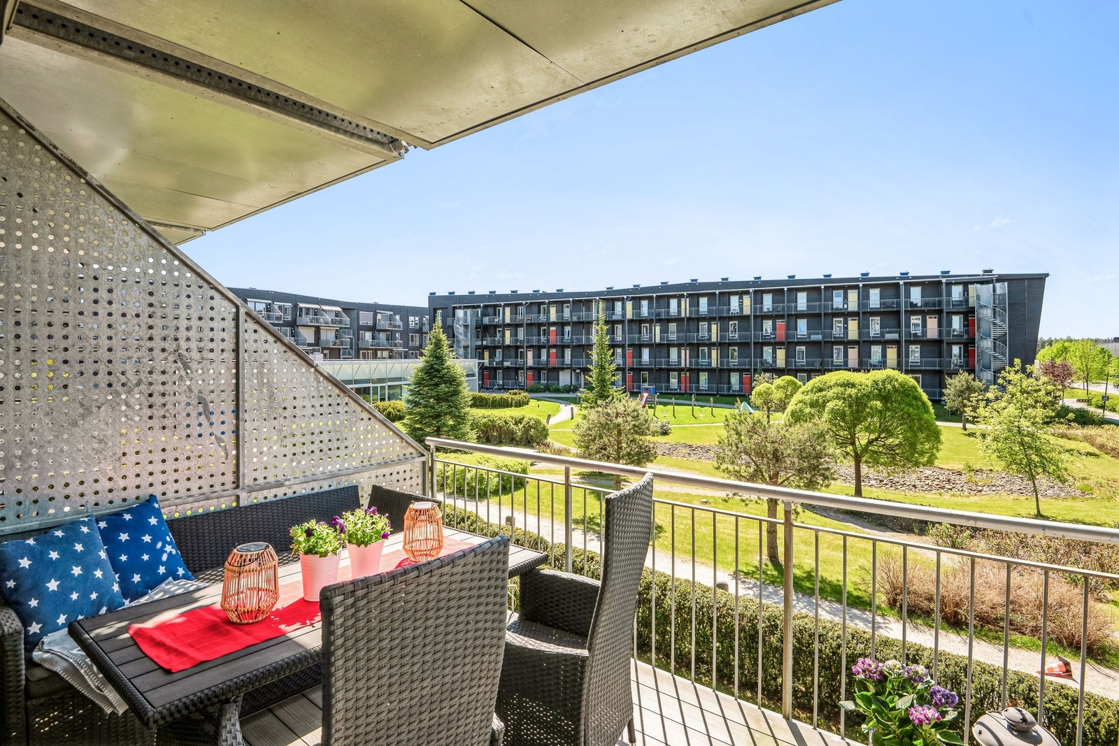 Sørvendt veranda med utsikt over fellesområde. Elektrisk markise. Galleribilde