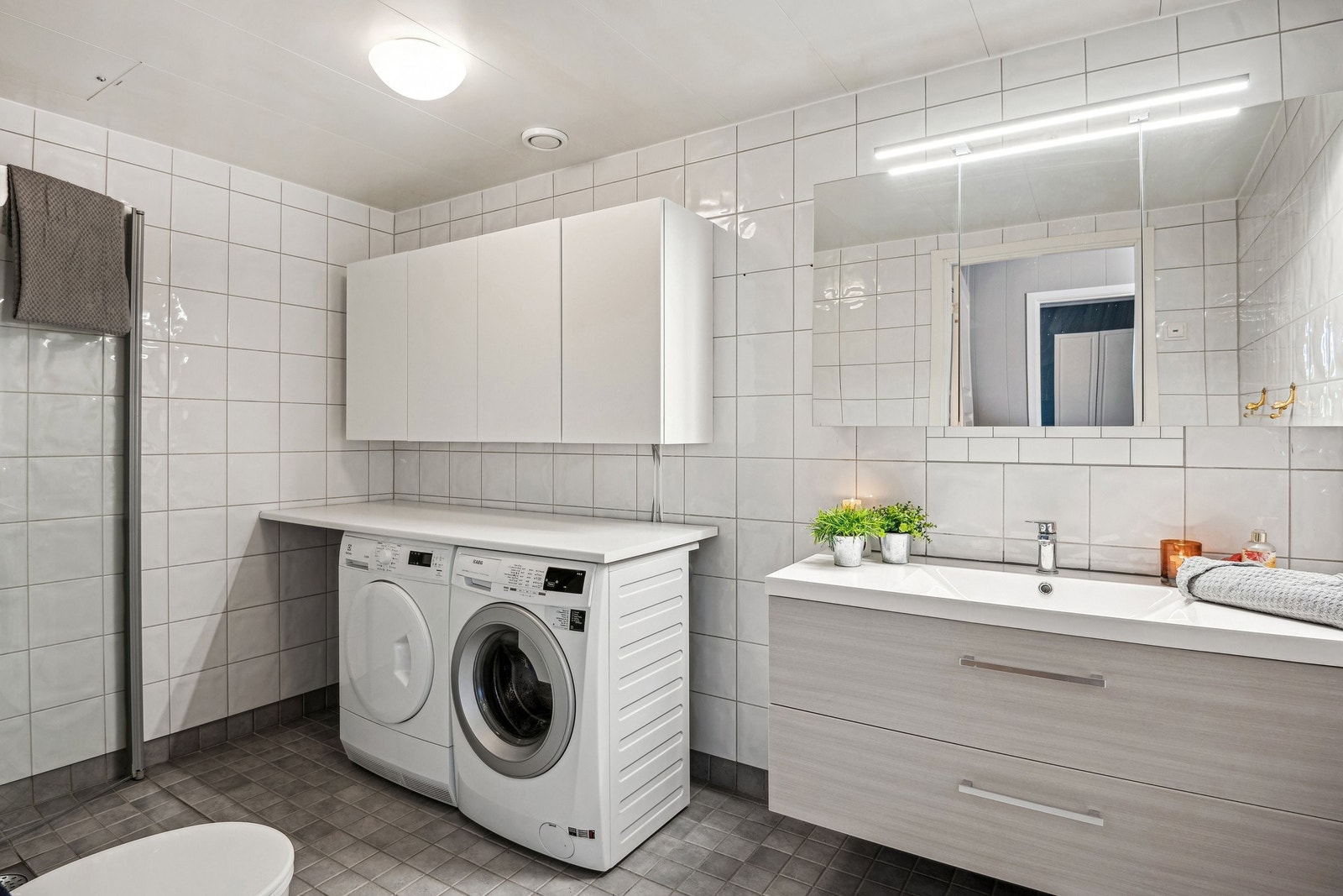 Stort lyst flislagt bad oppgradert med ny innredning i 2024. Montert skap for ekstra skap plass Galleribilde