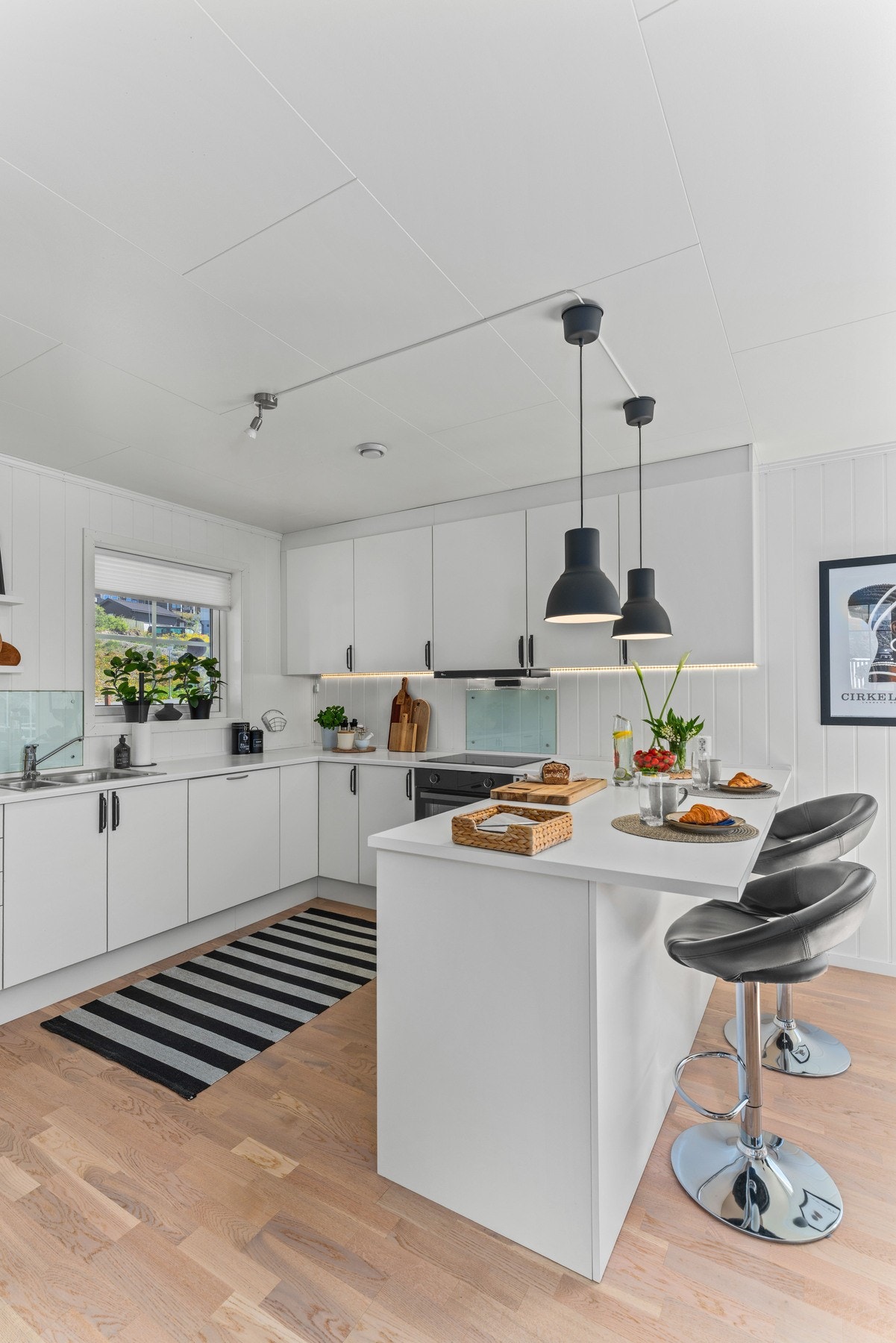 Kjøkkenet har også en praktisk halvøy med barstoler - perfekt som frokostplass eller sosial sone under matlaging. Galleribilde