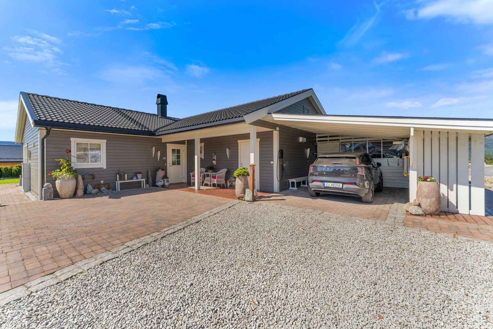 Det medfølger en romslig utebod med god lagringsplass for hageredskaper, sportsutstyr og annet. I tilknytning til boligen er det også en praktisk carport med elbillader. Galleribilde