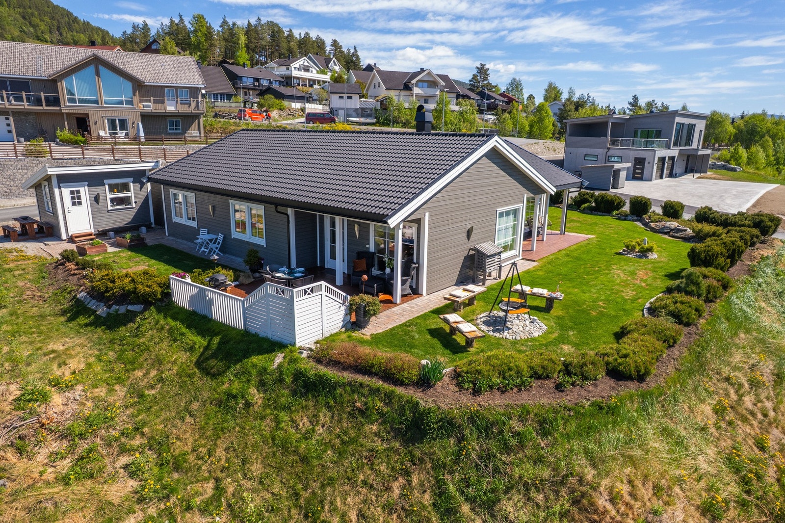 Uteområdet er virkelig noe for seg selv: Særdeles pent opparbeidet med grønn plen, blomsterbed, kantstein, brostein og vakre innslag av naturstein. Galleribilde