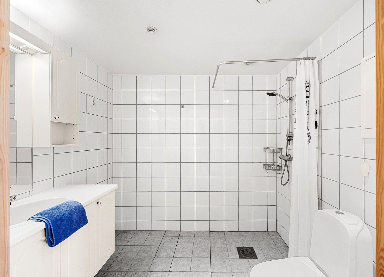 Baderommet fremstår som lyst og funksjonelt med fliser på både gulv og vegger. Det er god plass til oppbevaring, og rommet har opplegg for vaskemaskin, noe som gjør hverdagen ekstra praktisk. Galleribilde