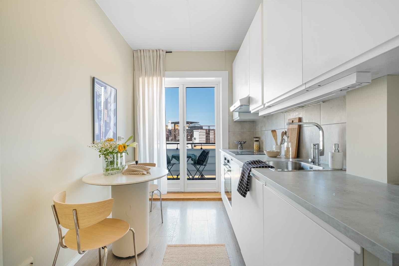 Tidsriktig glatt innredning fra IKEA, soft close, fliser over benk, armatur, laminat benkeplate med nedfelt stålkum og keramisk topp, integrert komfyr, oppvaskmaskin (smal type). Direkte adkomst til balkong. Galleribilde