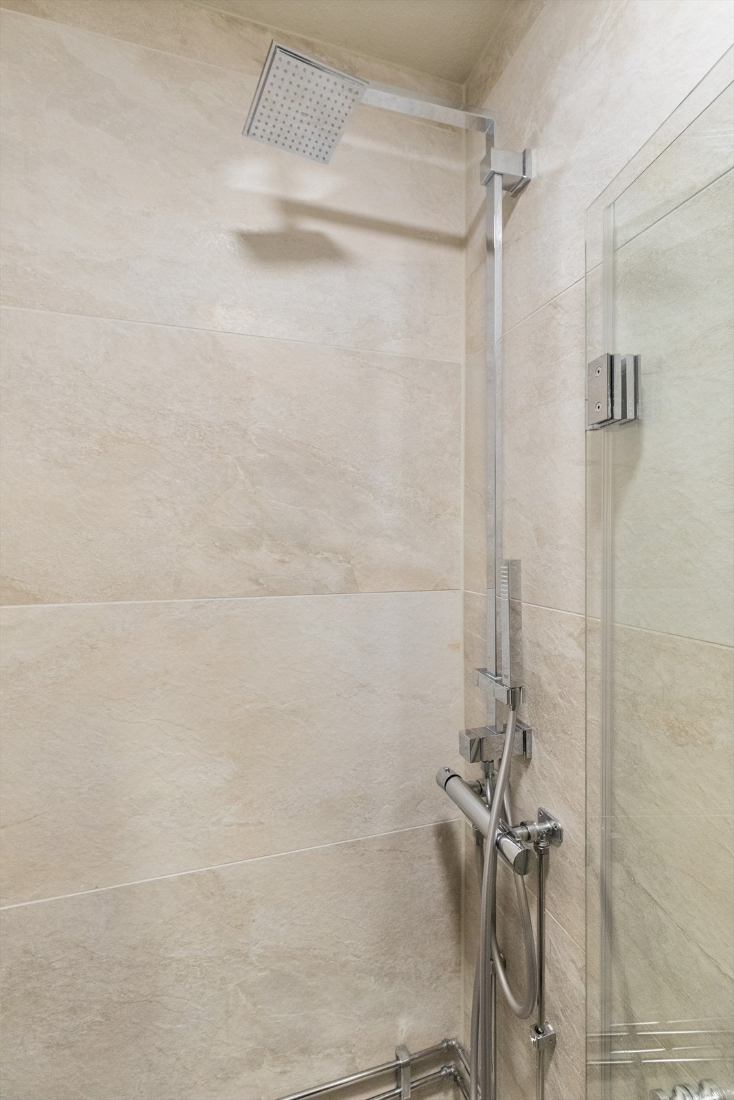 Badet har videre dusjhjørne med innfellbare glassdører og vegghengt toalett. Avtrekksventil for mekanisk avtrekk er plassert på vegg. Galleribilde