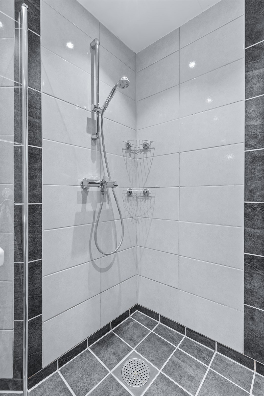 Romslig, helfliset bad med varmekabler i gulv og downlights i himling Galleribilde