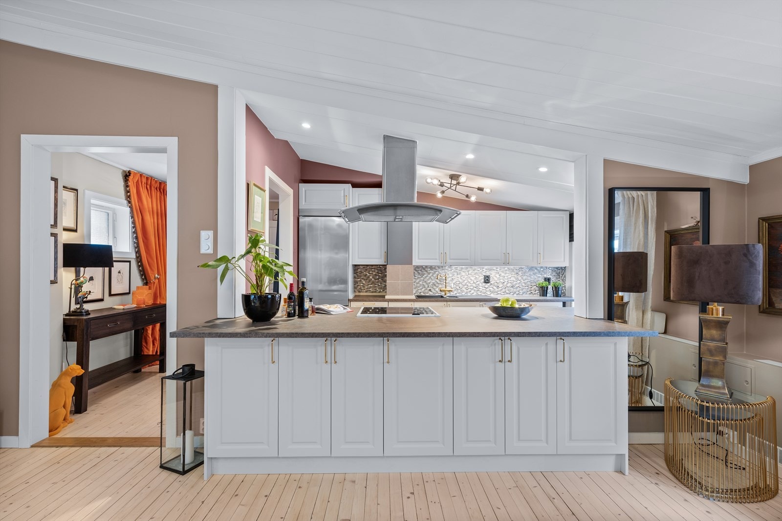 Stuen ligger i delvis åpen løsning mot kjøkken, adskilt med integrert kjøkkenbenk Galleribilde