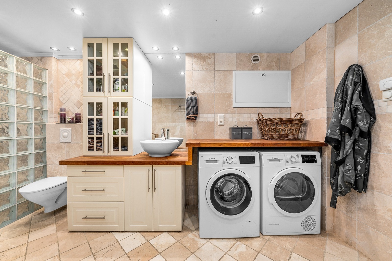 Vaskeromsdel med praktisk innredning, god benkeplass og plass til både vaskemaskin og tørketrommel. Galleribilde