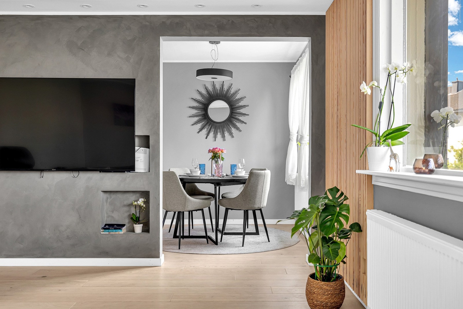 Rommet er holdt i moderne farger og en svært moderne spilevegg er montert på vegg mot kjøkkenet. Galleribilde